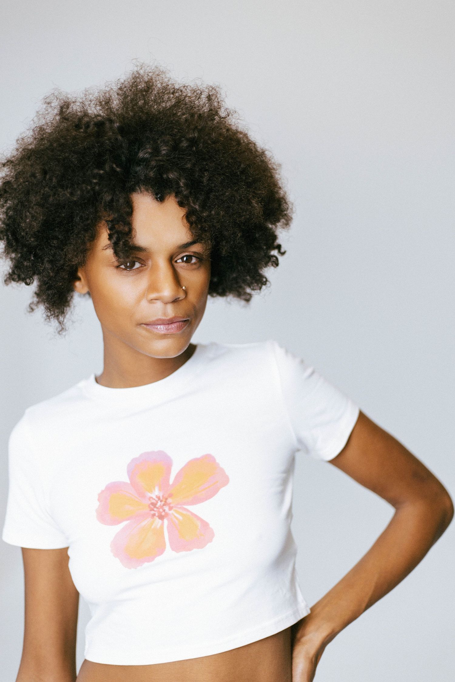 A series of fashion portraits showing a white t-shirt with a pink floral design against a light gray background.