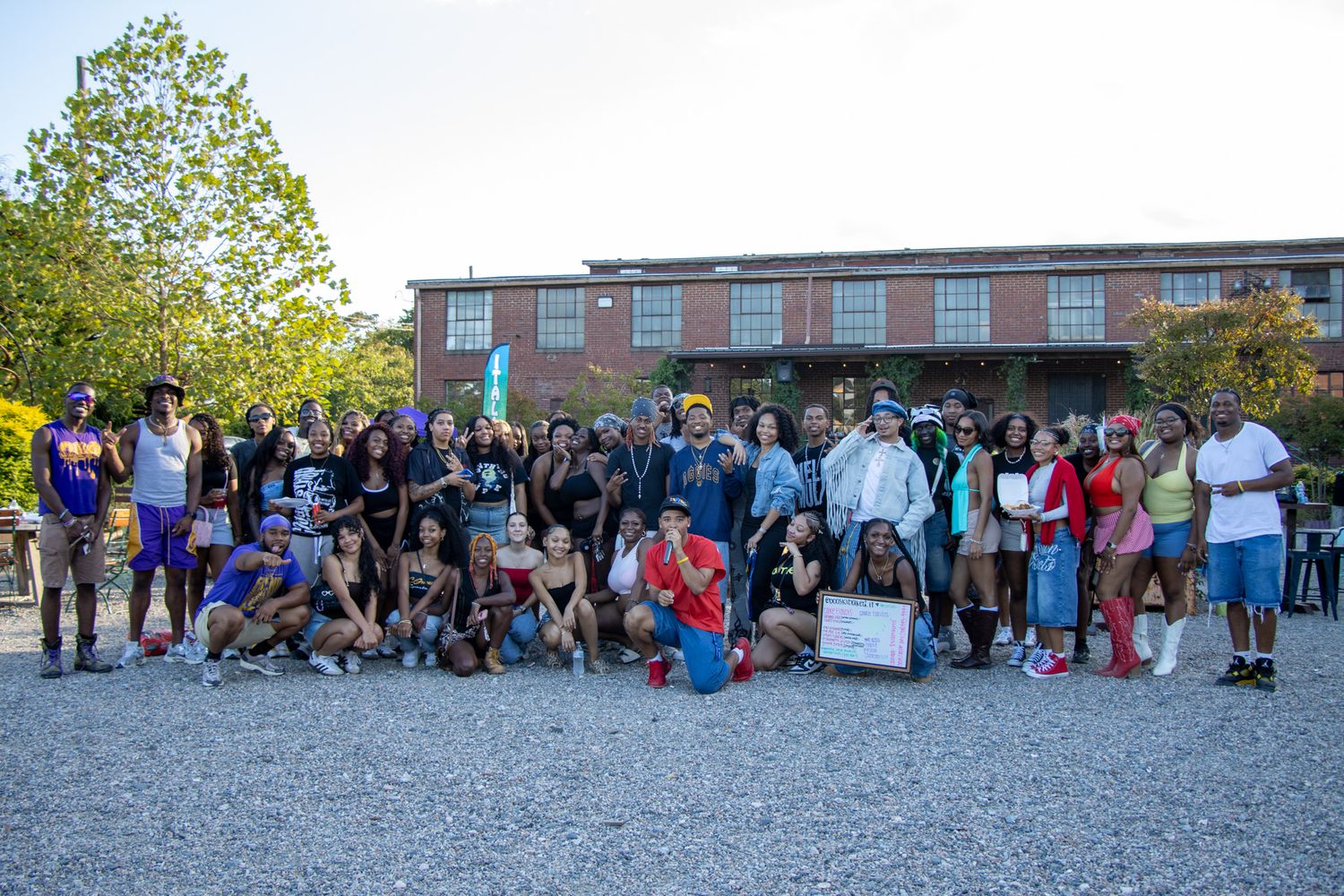 A large group of people gathered in a line formation outdoors during a community event.