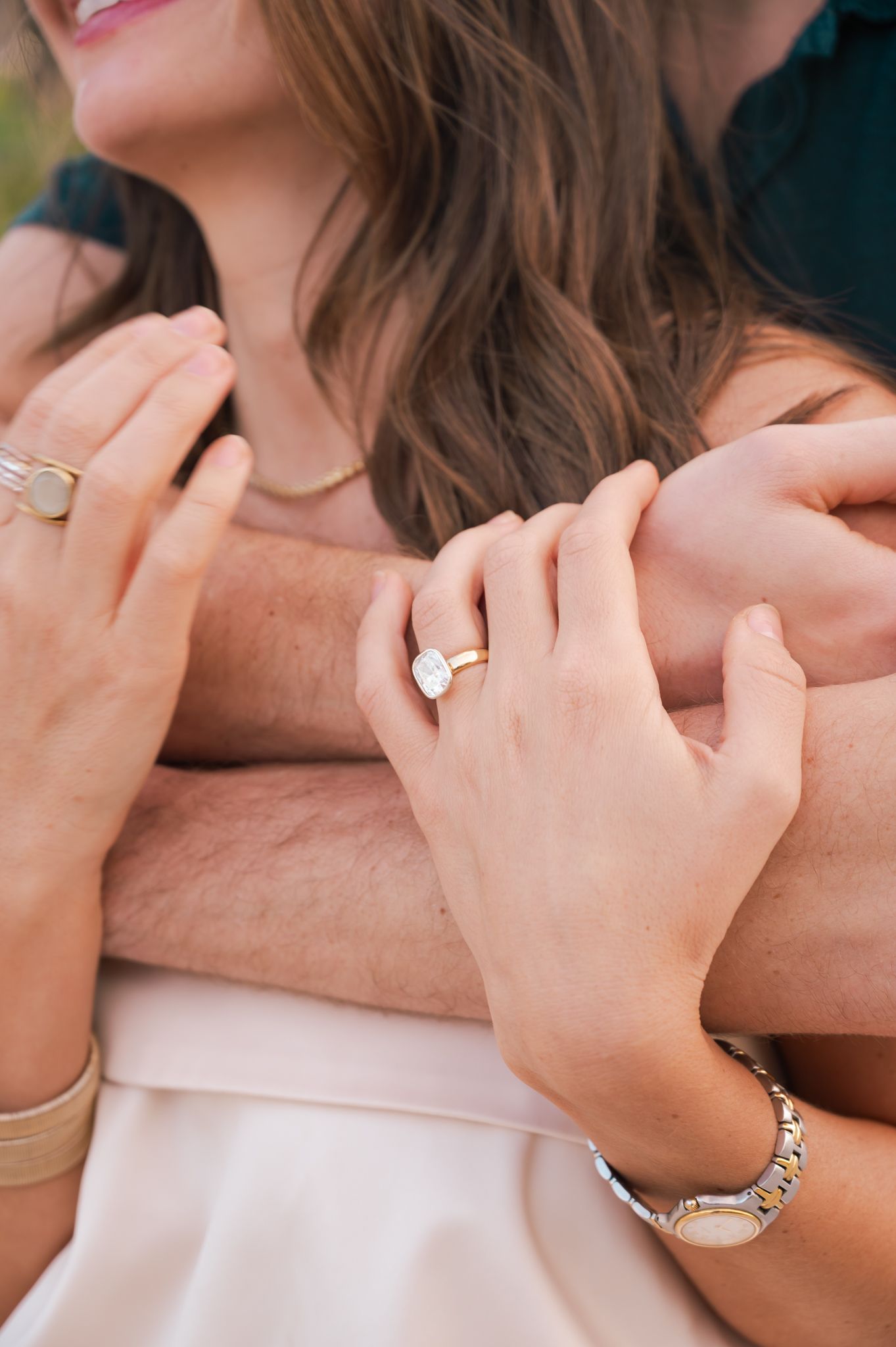 Detail shots of hands wearing engagement rings and jewelry against soft backgrounds.
