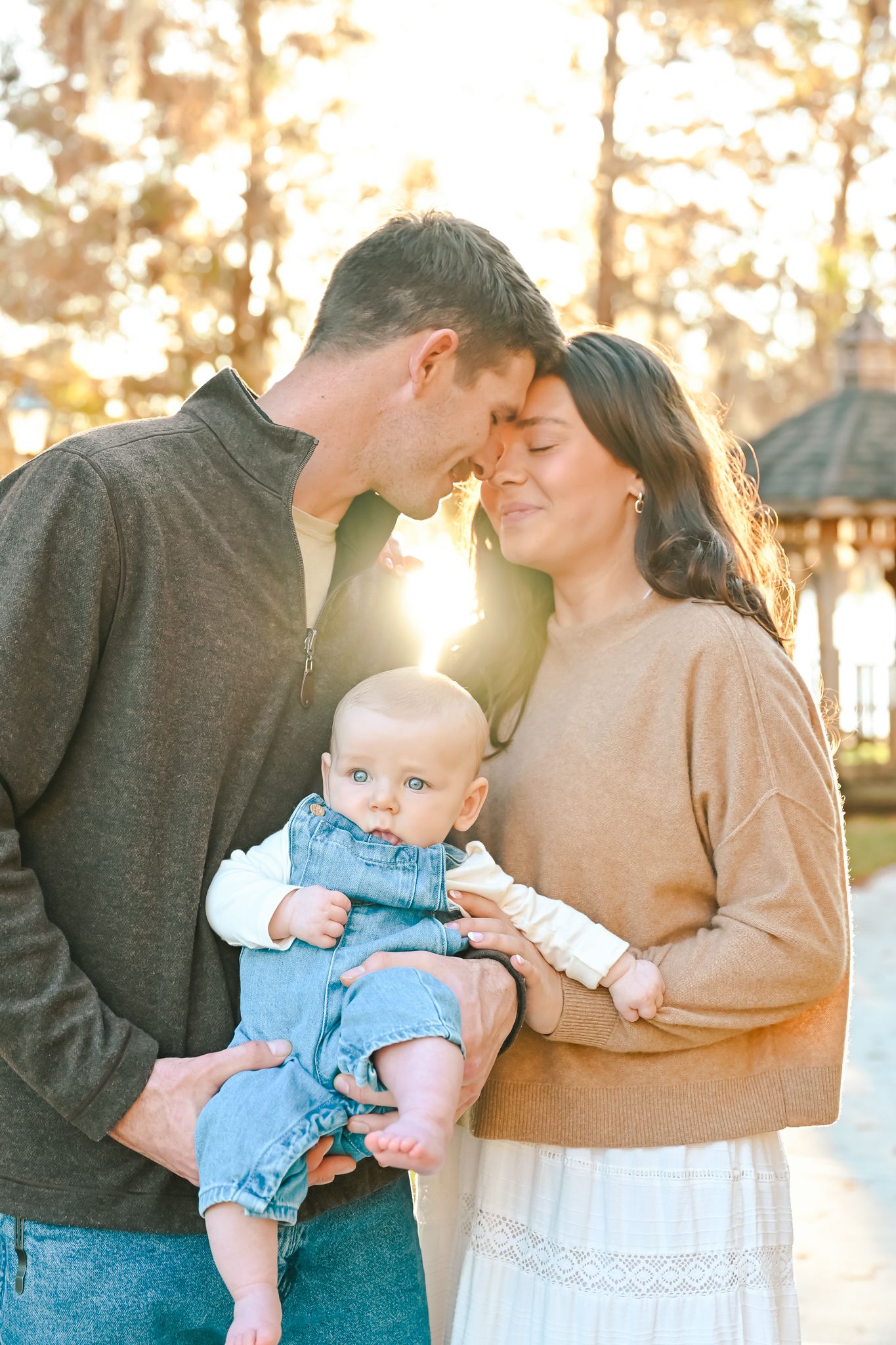 Candid family portraits showing loving interactions at sunset.