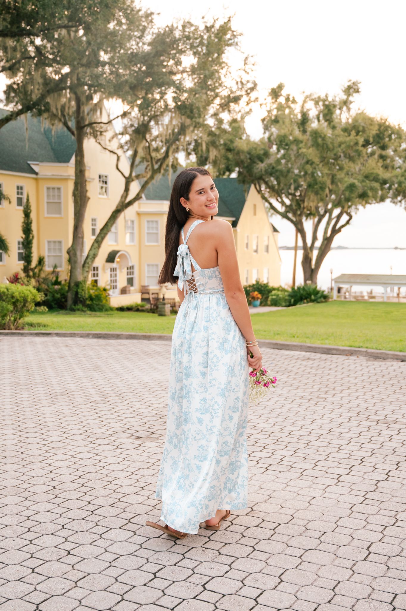 Outdoor photoshoot on hexagonal pavers featuring light blue floral dress.
