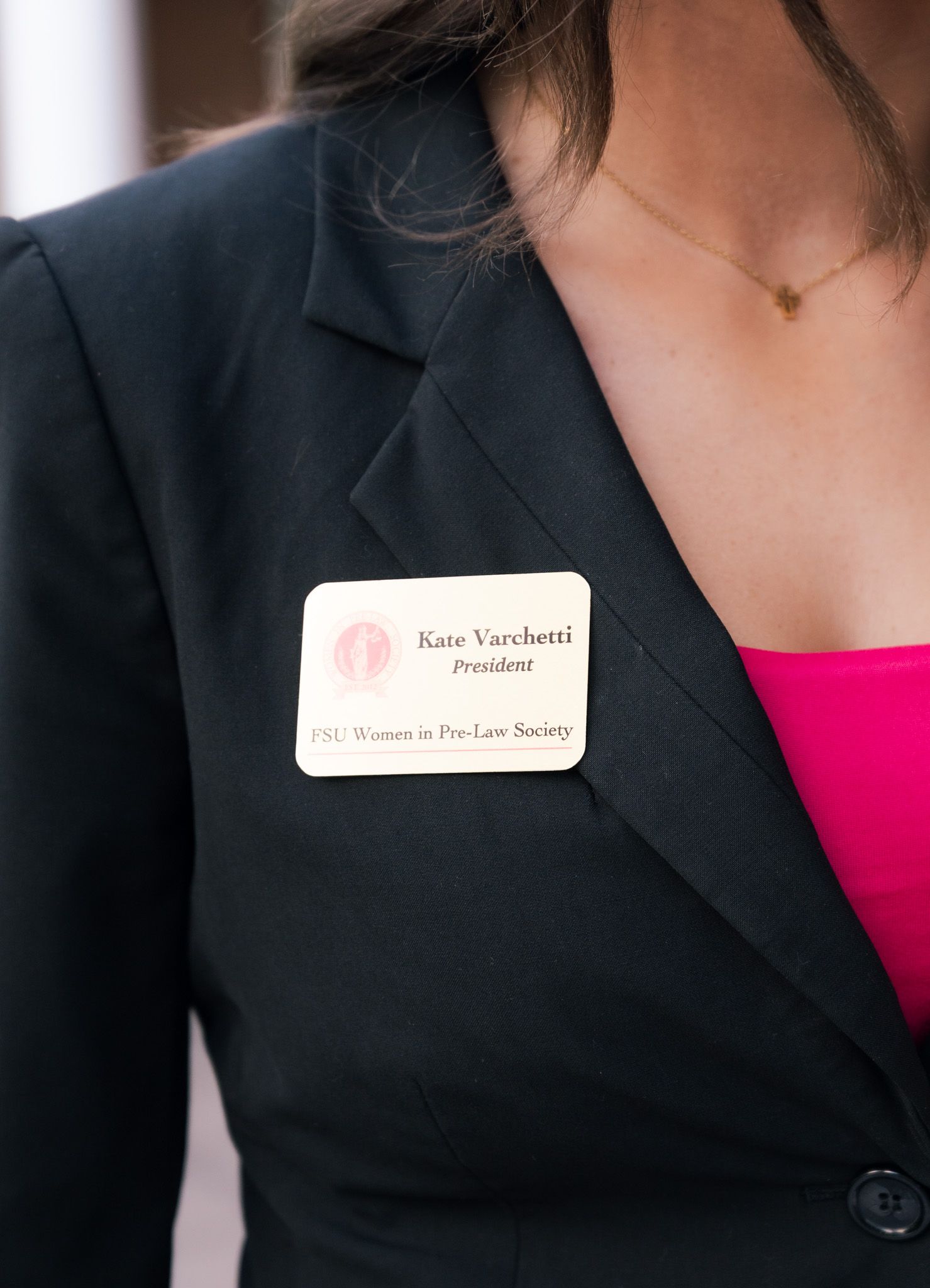 Woman in black blazer wearing a name tag reading Kate Varchetti, President of FSU Women in Pre-Law Society.