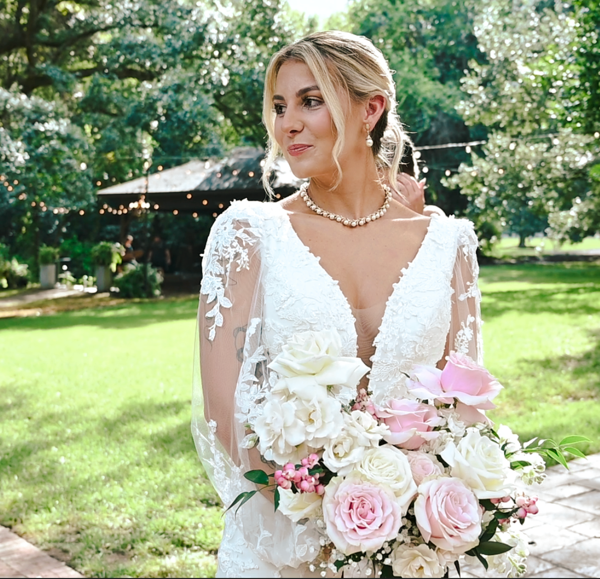 Beautiful wedding bouquet featuring white and pink roses against a sunny outdoor background.