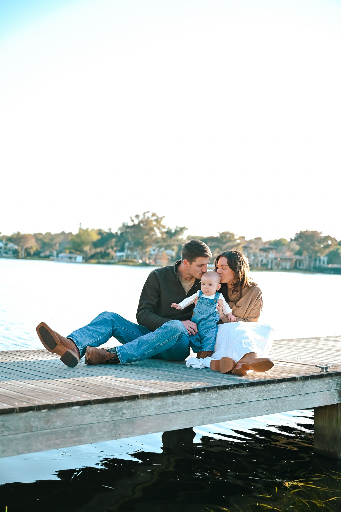Family spending quality time together lying on a lakeside dock.