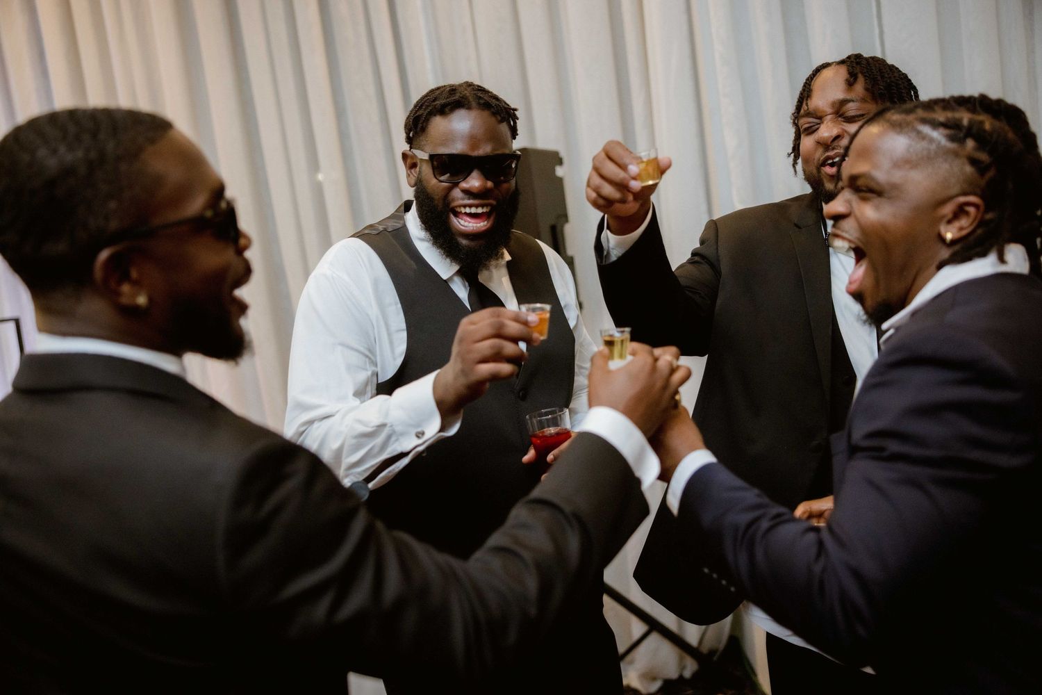 Guests laugh and celebrate during a lively wedding reception party.