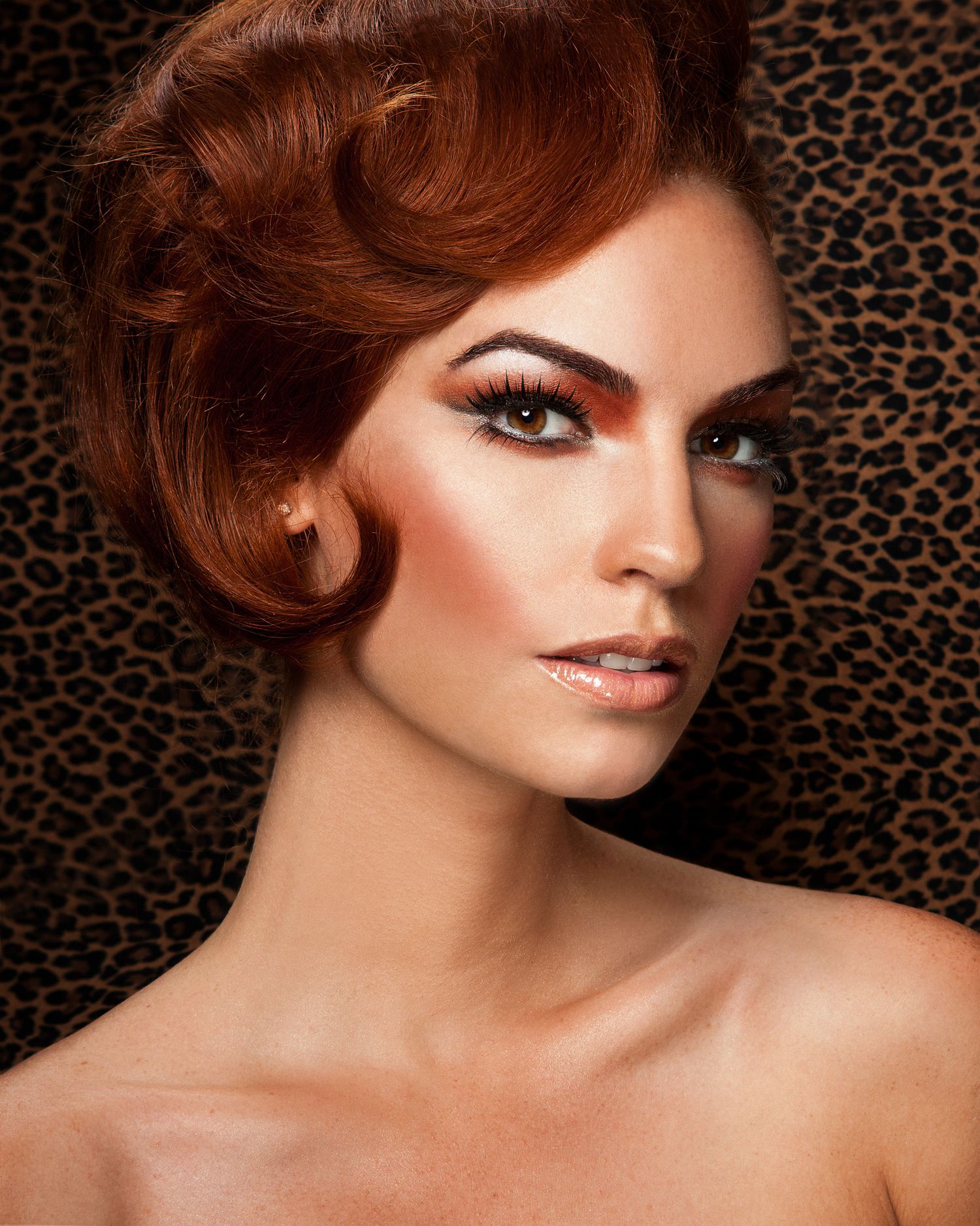 Glamorous beauty portrait with dramatic makeup against a leopard print background.