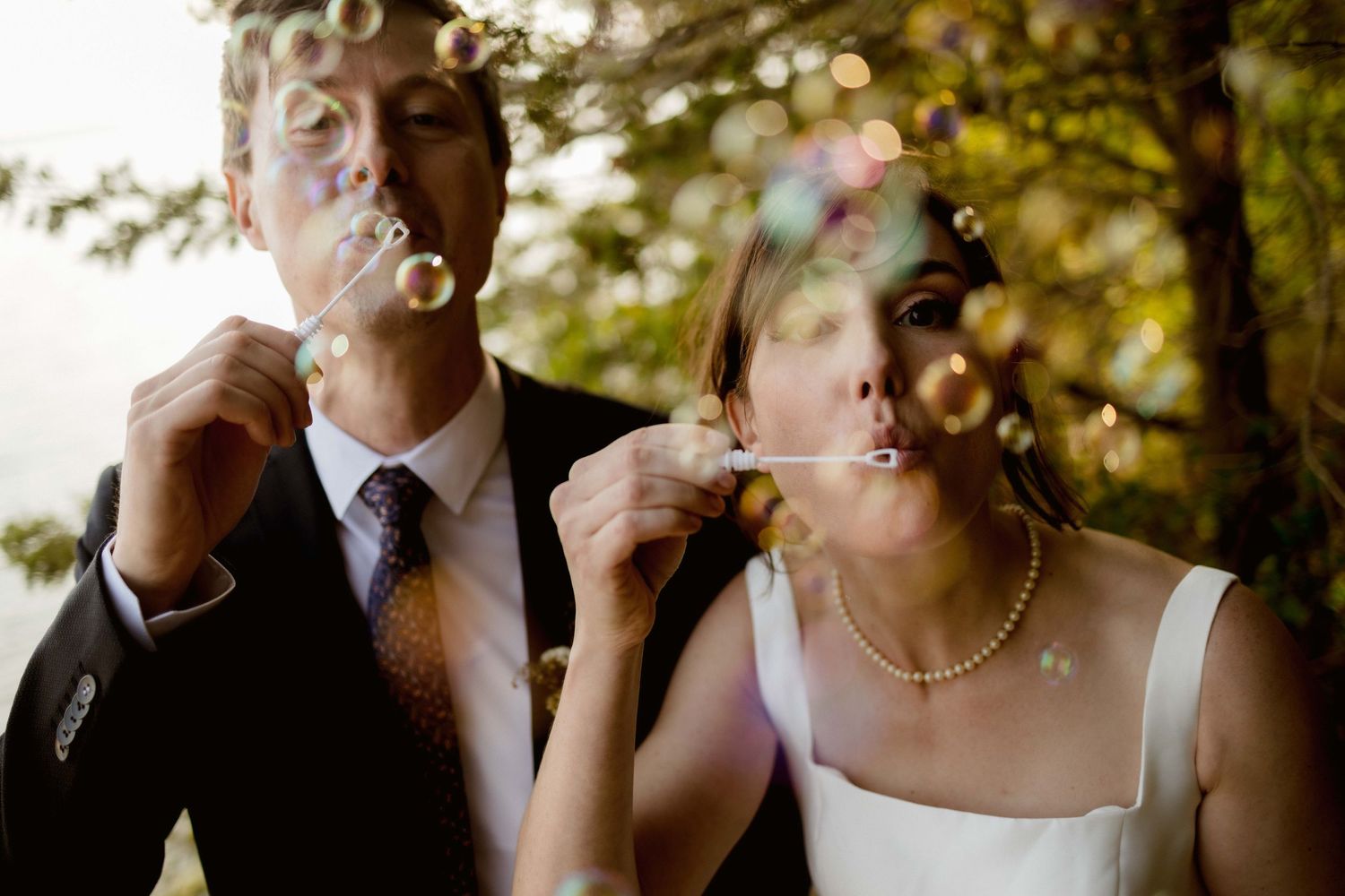 Candid moments captured during an outdoor wedding celebration with natural bokeh effects.