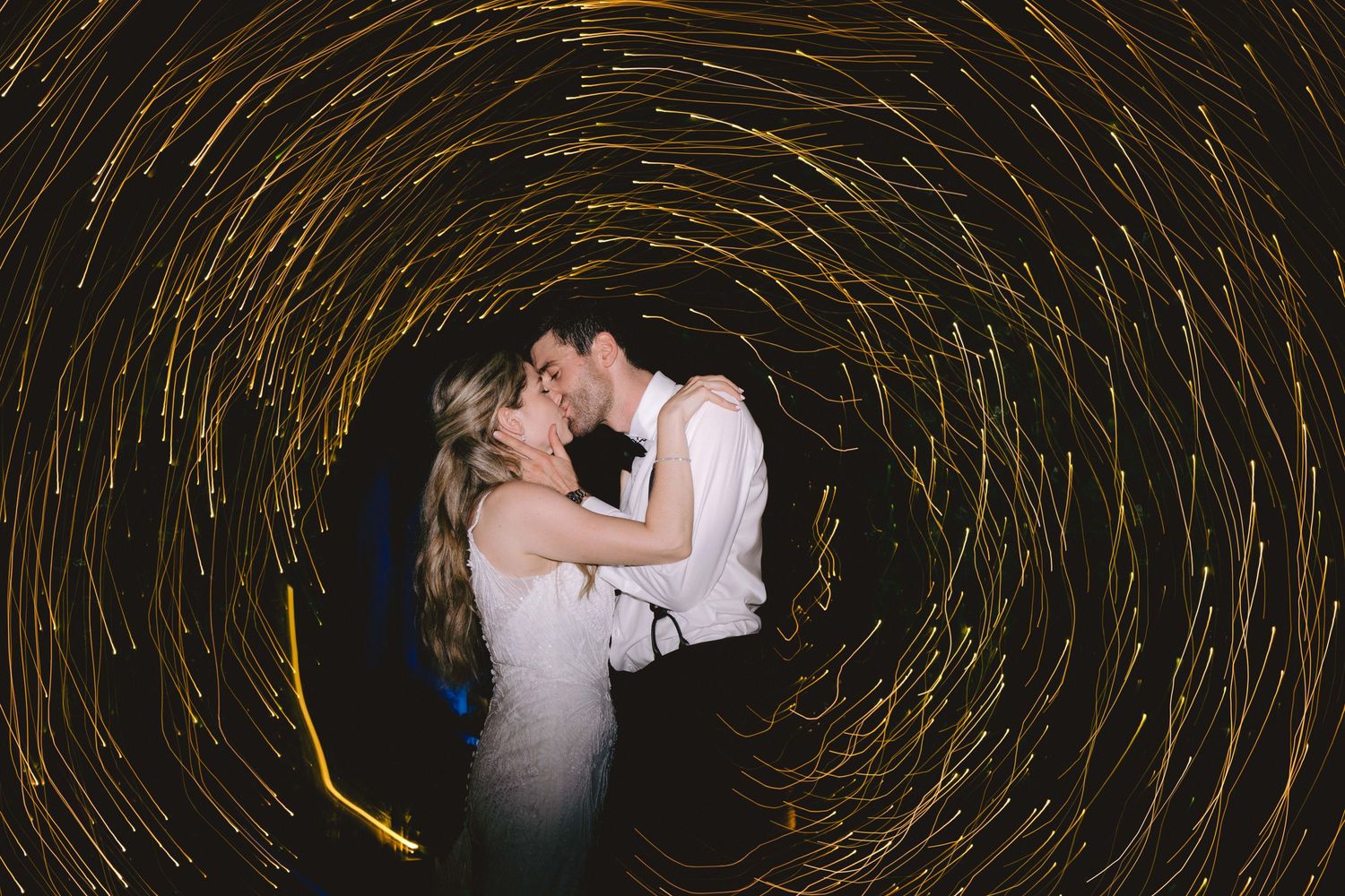 Wedding couple dancing with swirling light trails creating a magical effect.