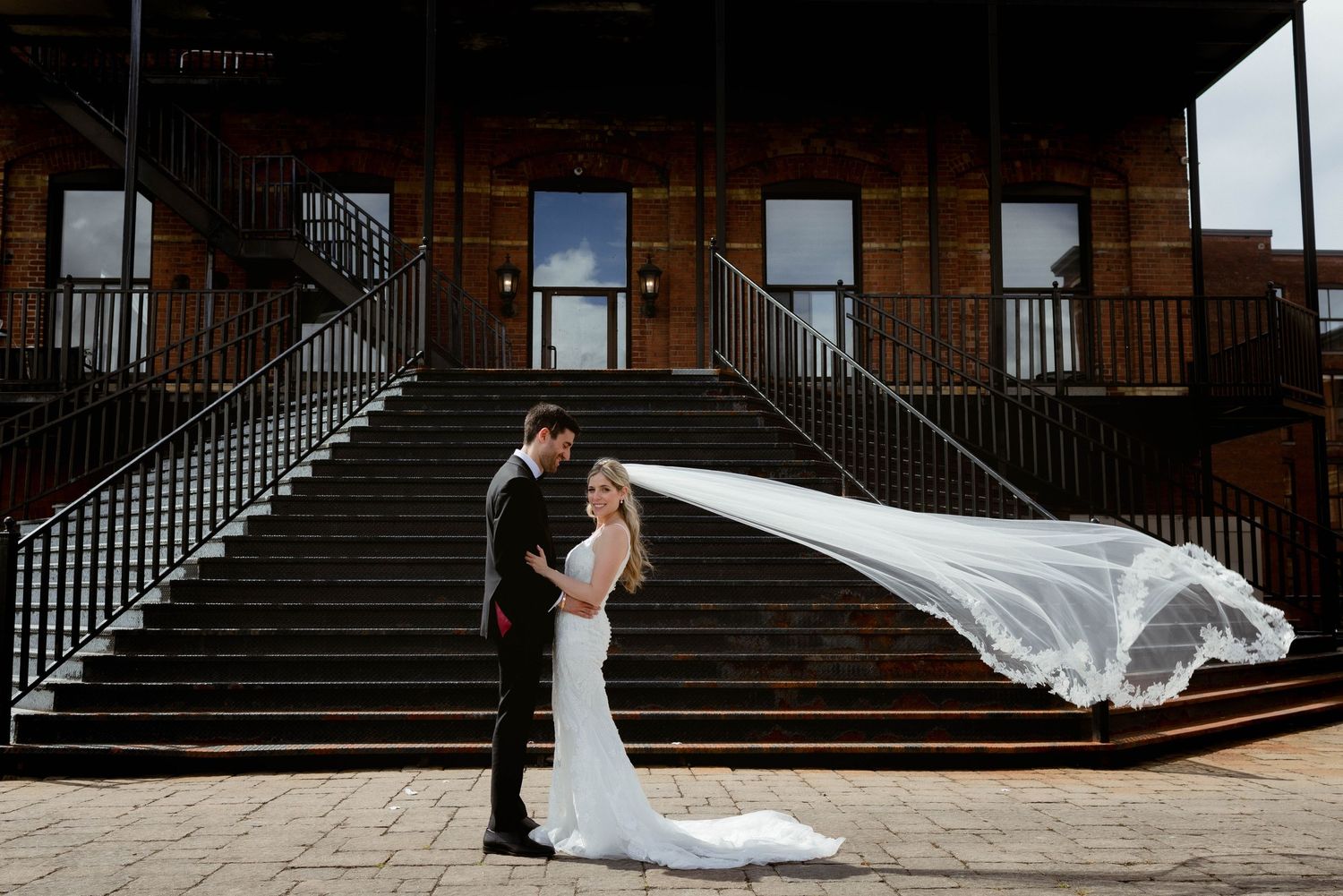 Wedding photography session on dark brick steps with dramatic composition.