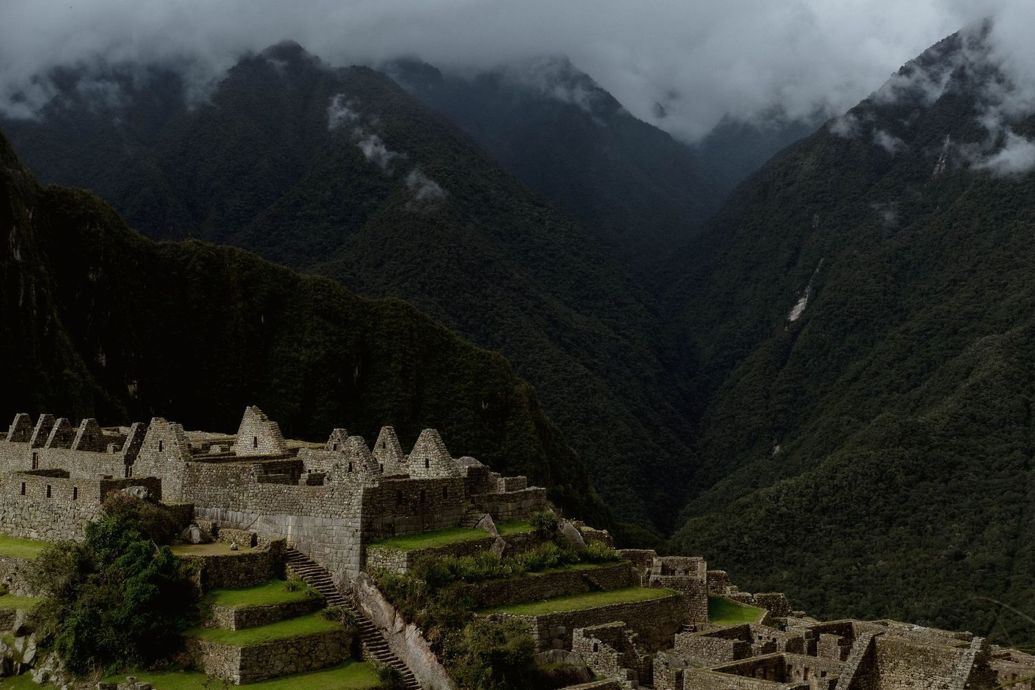 Ancient Incan ruins of Machu Picchu nestled in misty Andean mountains.