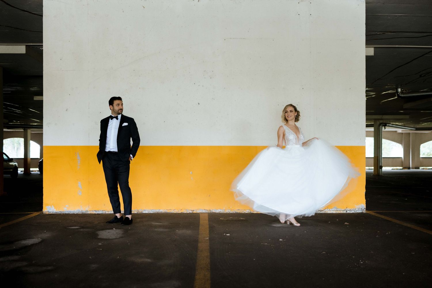 Creative wedding photo series showing silhouettes against bright orange and white backgrounds in a parking garage.