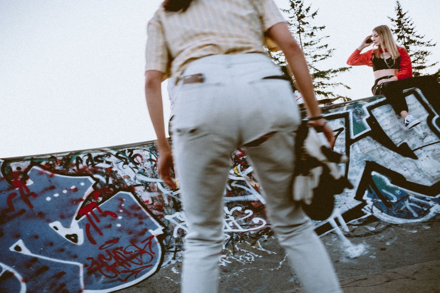 Close-up view of skateboarders against graffiti wall.