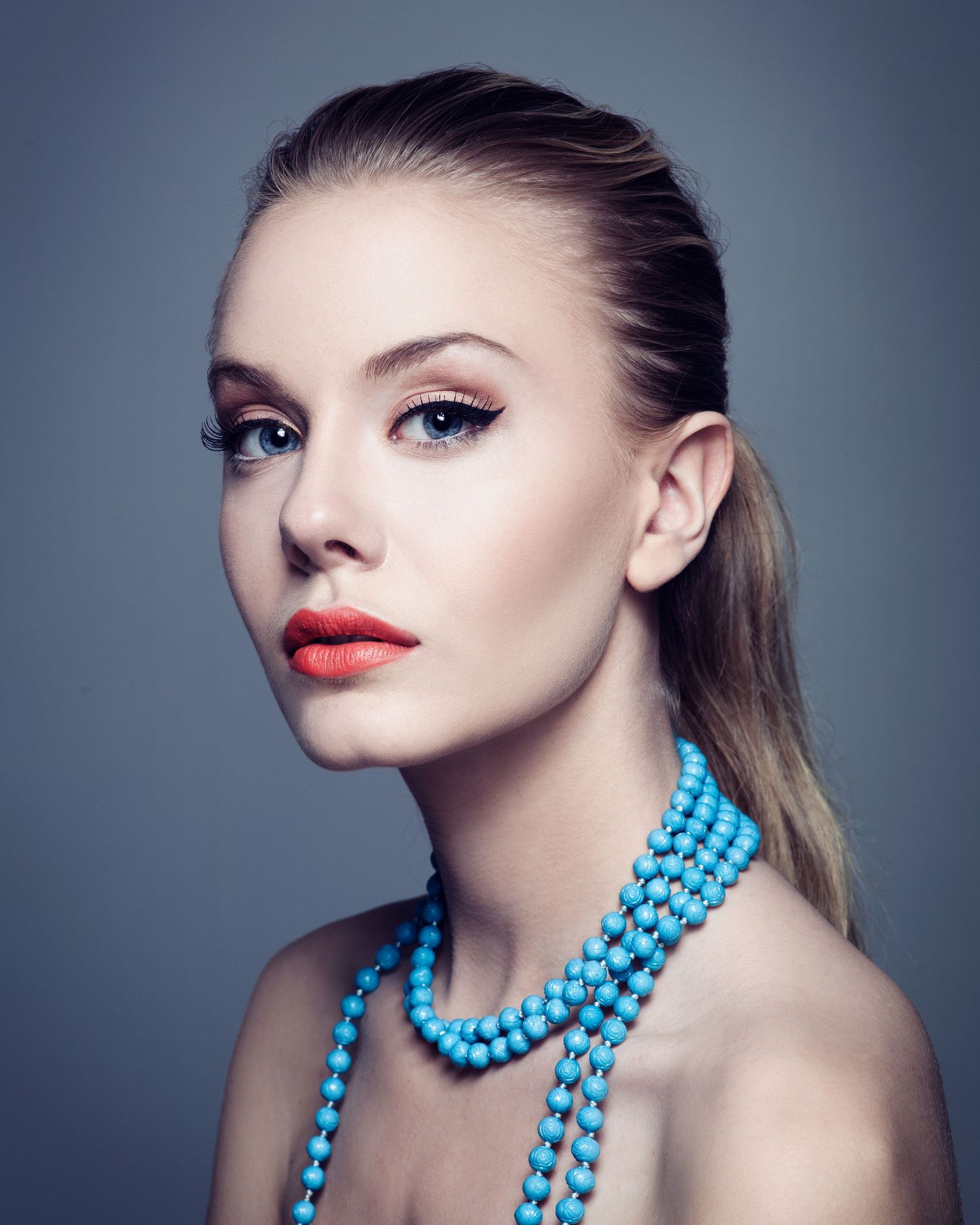 Glamour beauty shot with turquoise beaded necklace and flawless makeup.