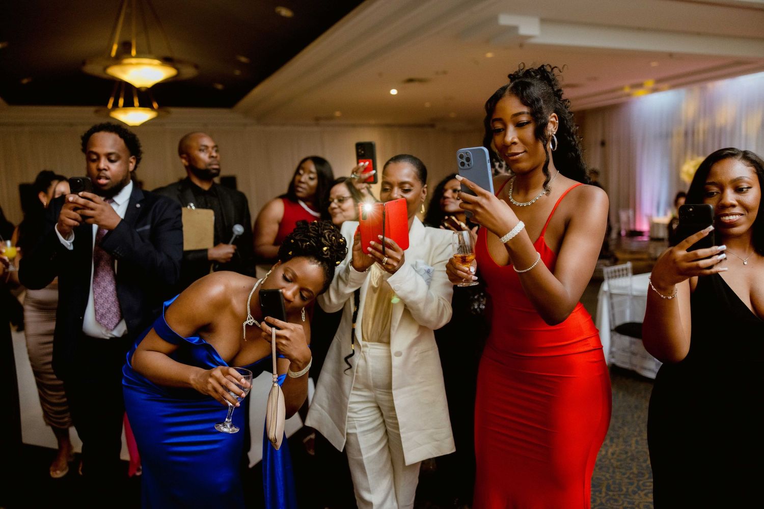 Wedding reception guests dance and celebrate with joy at an indoor venue.
