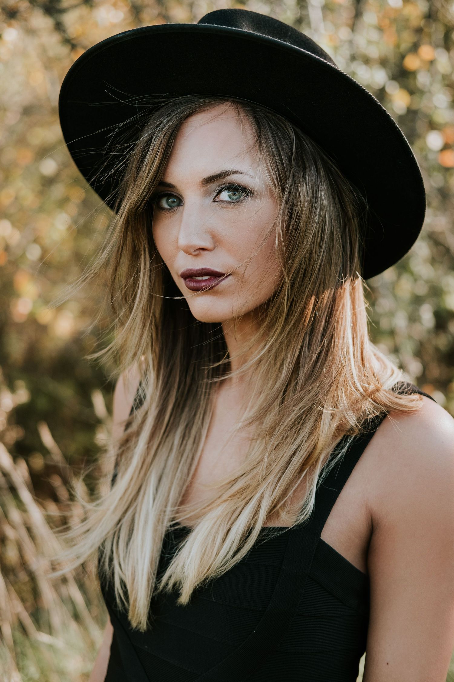 Bohemian style portrait with black hat and natural autumn background.