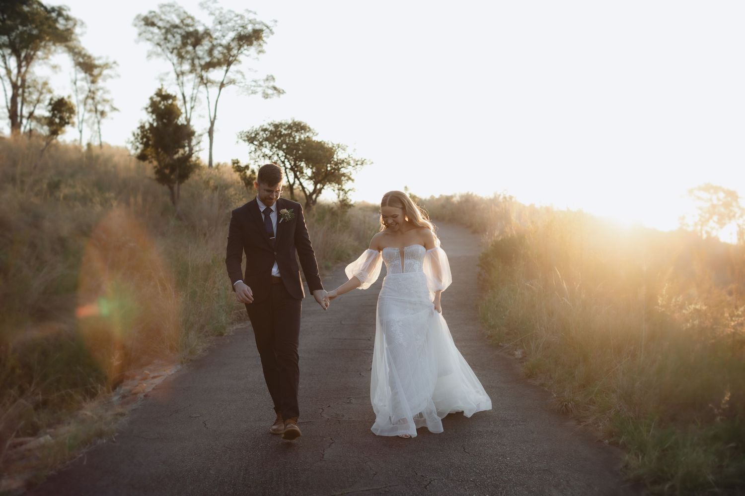 Bride and groom walking hand in hand on mountain road during intimate wedding in Gauteng, photo by Wouter Kleynhans wedding photographer