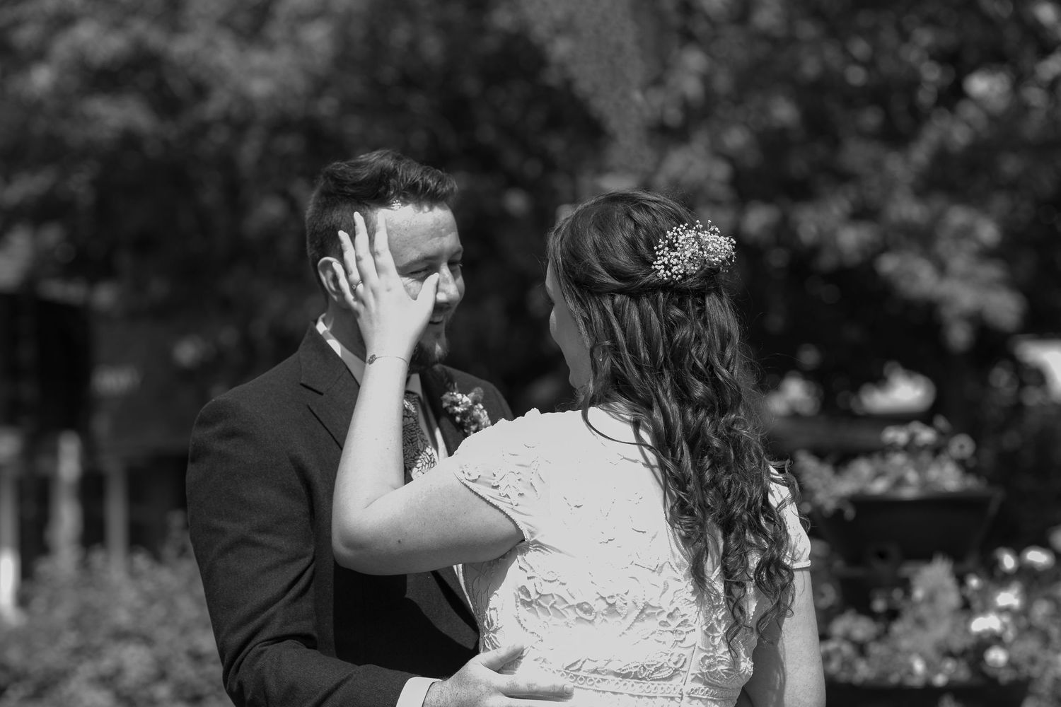 Bride wipes away a tear from the Groom's face after he sees his Bride for the first time.