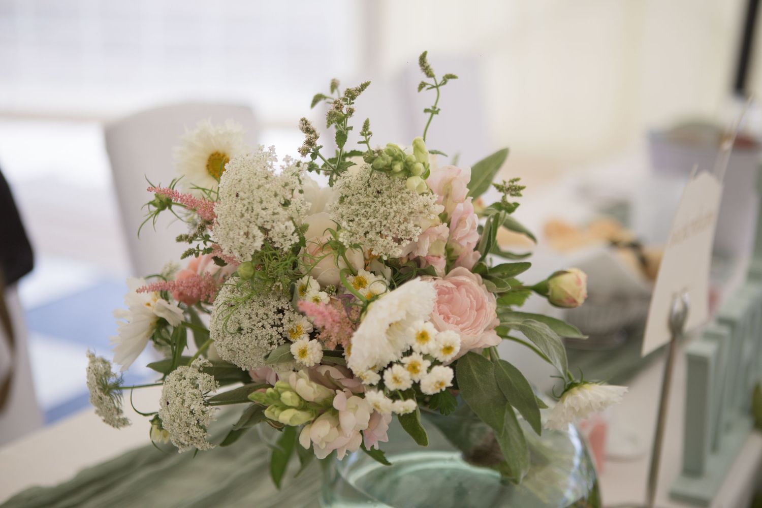 A Bride's bouquet left on the table. A bouquet of beautiful flowers in shades of white, light pink and lots of green.