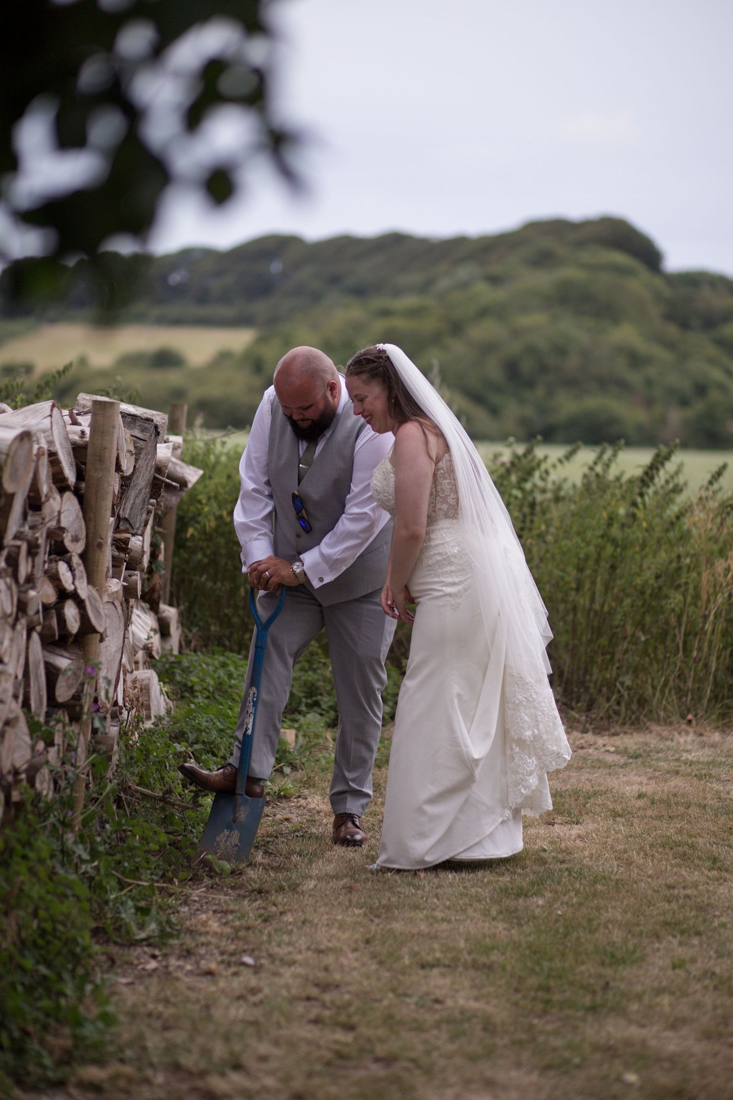 Bride and Groom digging up a bottle of whiskey they'd buried in the grounds of their wedding venue.