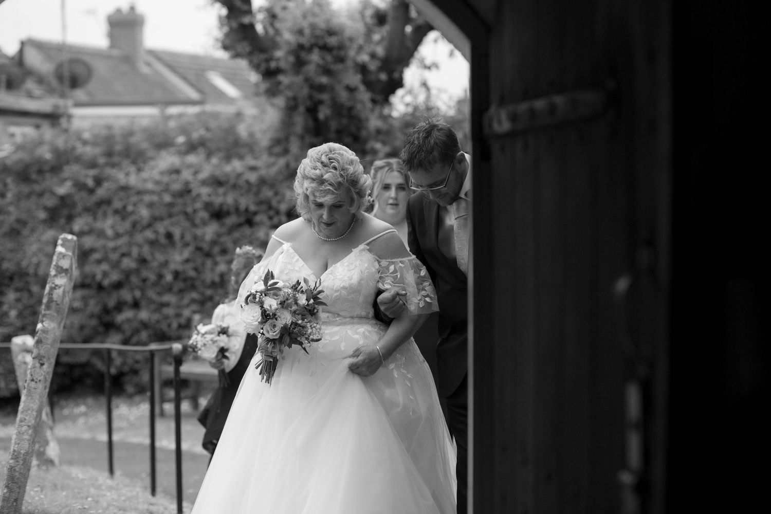 A Bride and her son waiting arm in arm, reading to enter the door to the church and start the wedding ceremony