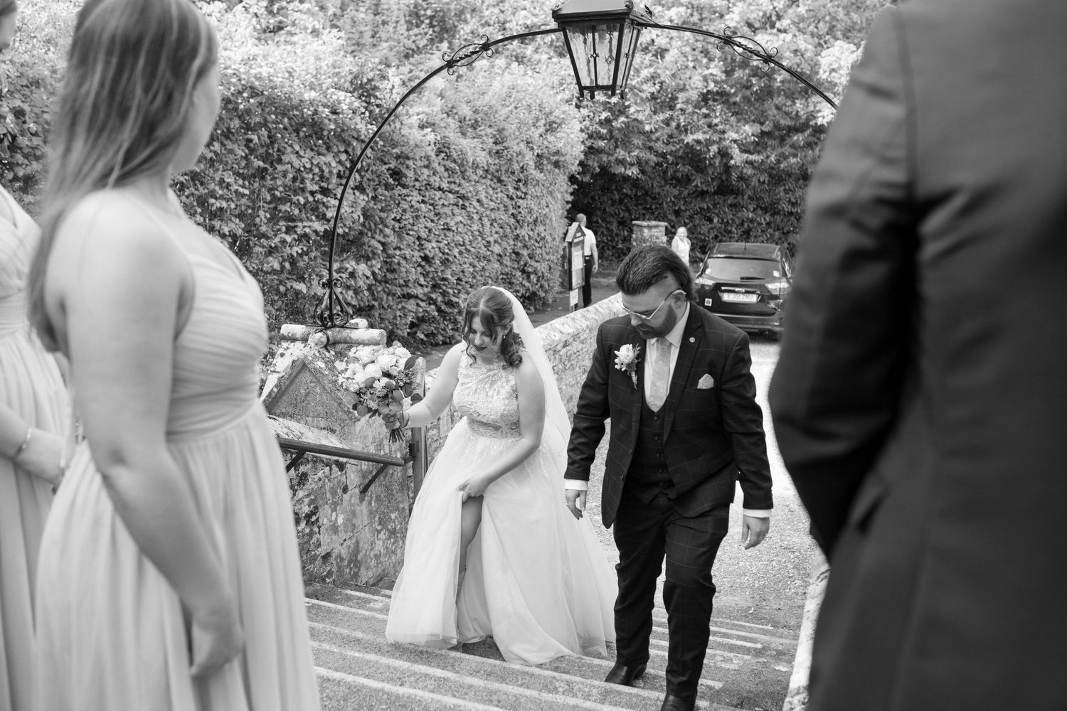 Bride and Groom arrive and walk up the stairs to the church for their wedding blessing, as their wedding party waits at the top