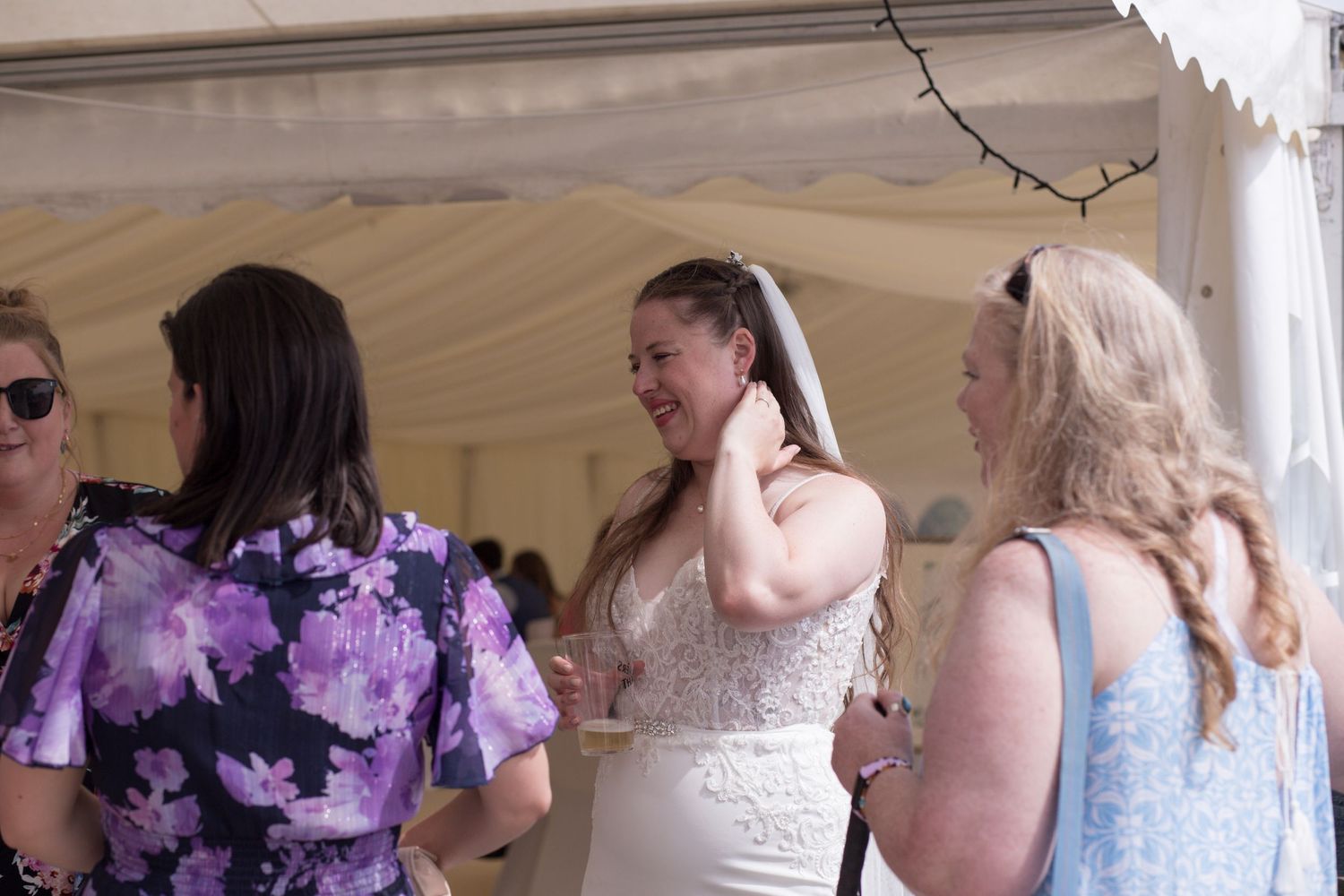 A Bride smiling and laughing with her guests.