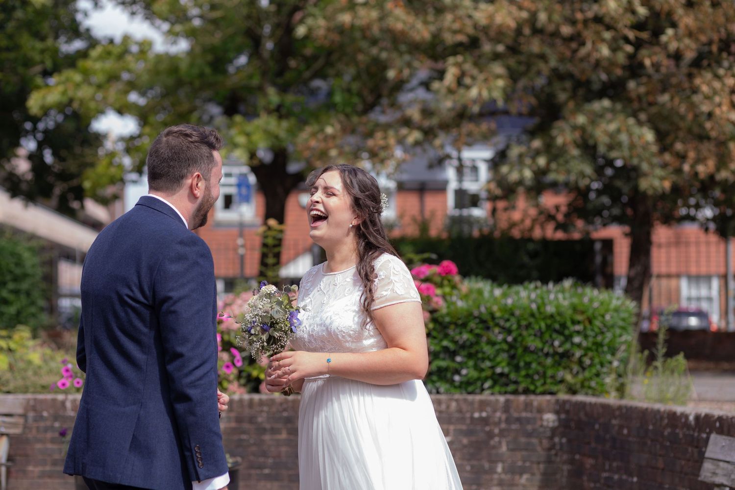 Bride laughs loudly at her Groom during a private moment in their First look