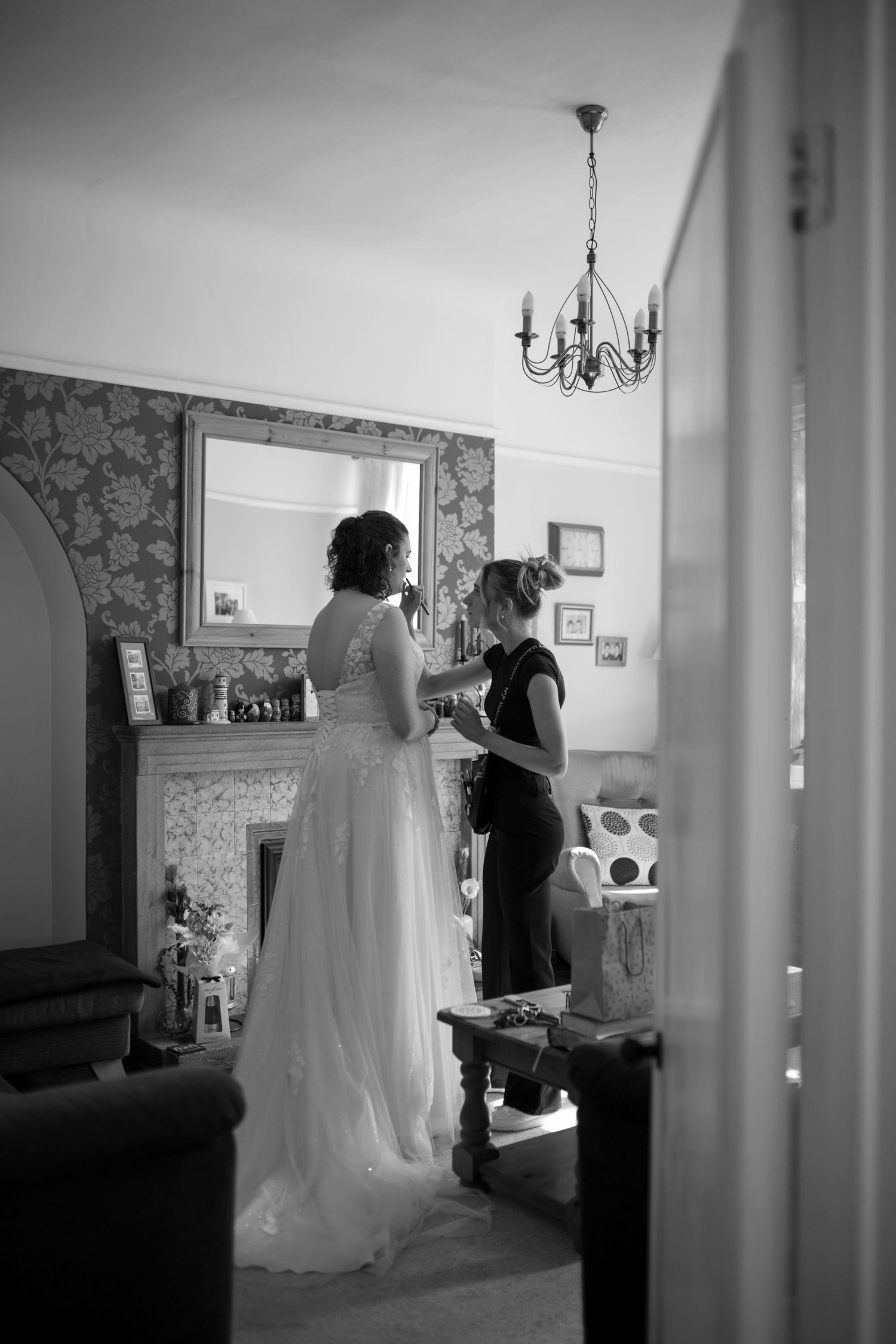 Make Up Artist doing final touch ups of a Brides make up in the Bride's childhood living room