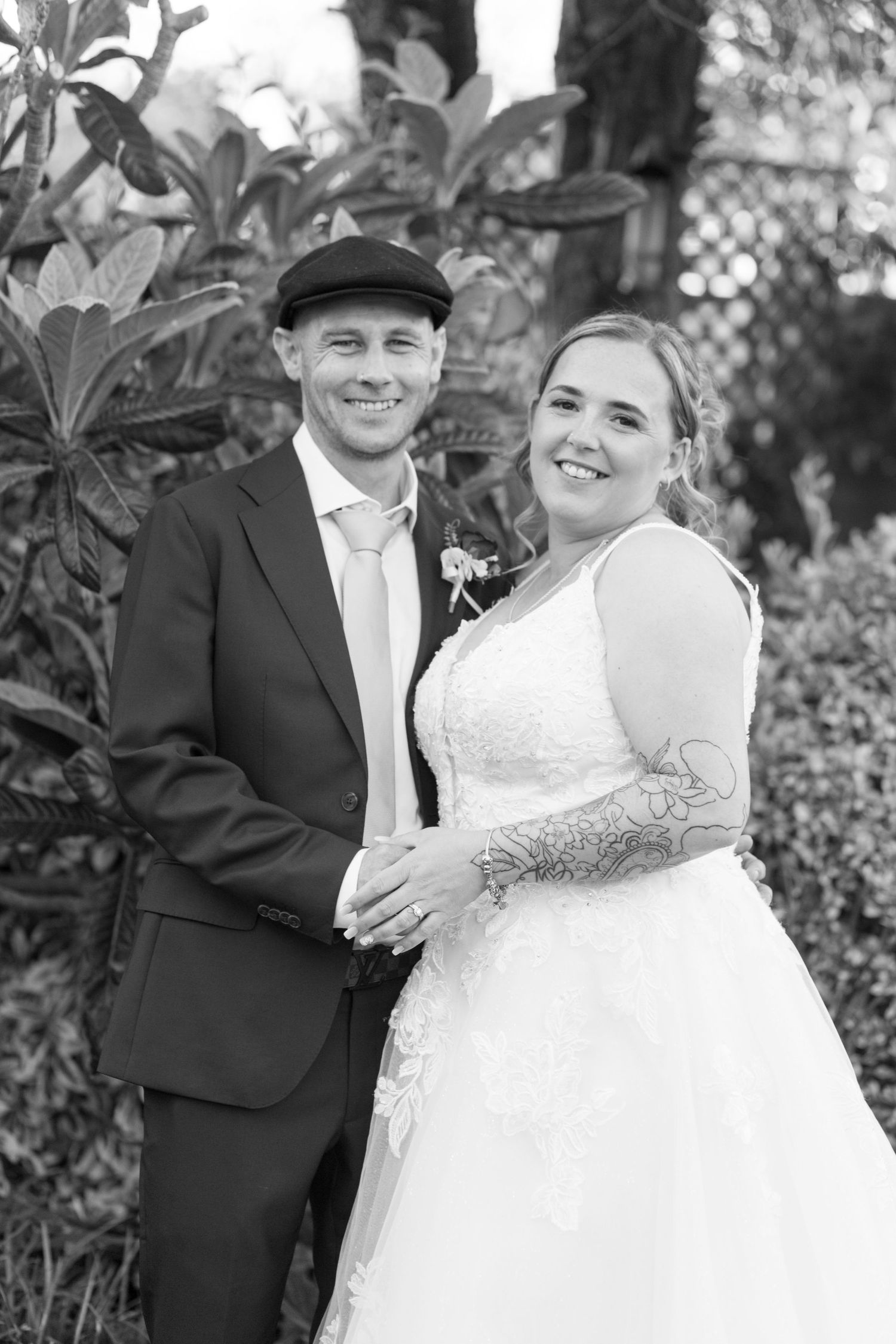 Black and White photo of a bride and groom stood smiling together.