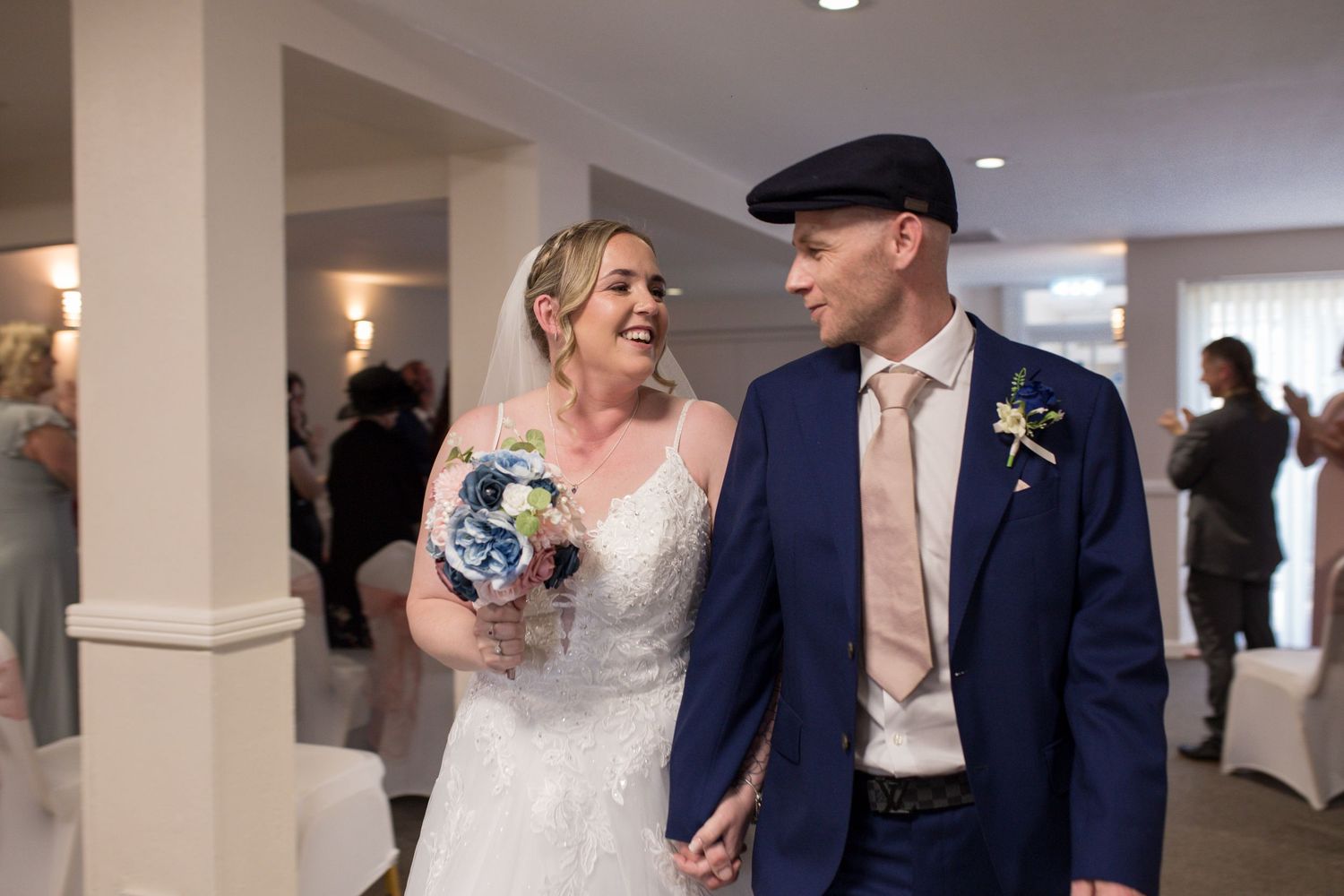 Bride and Groom share a smile as they finish walking back down the aisle at the end of their ceremony