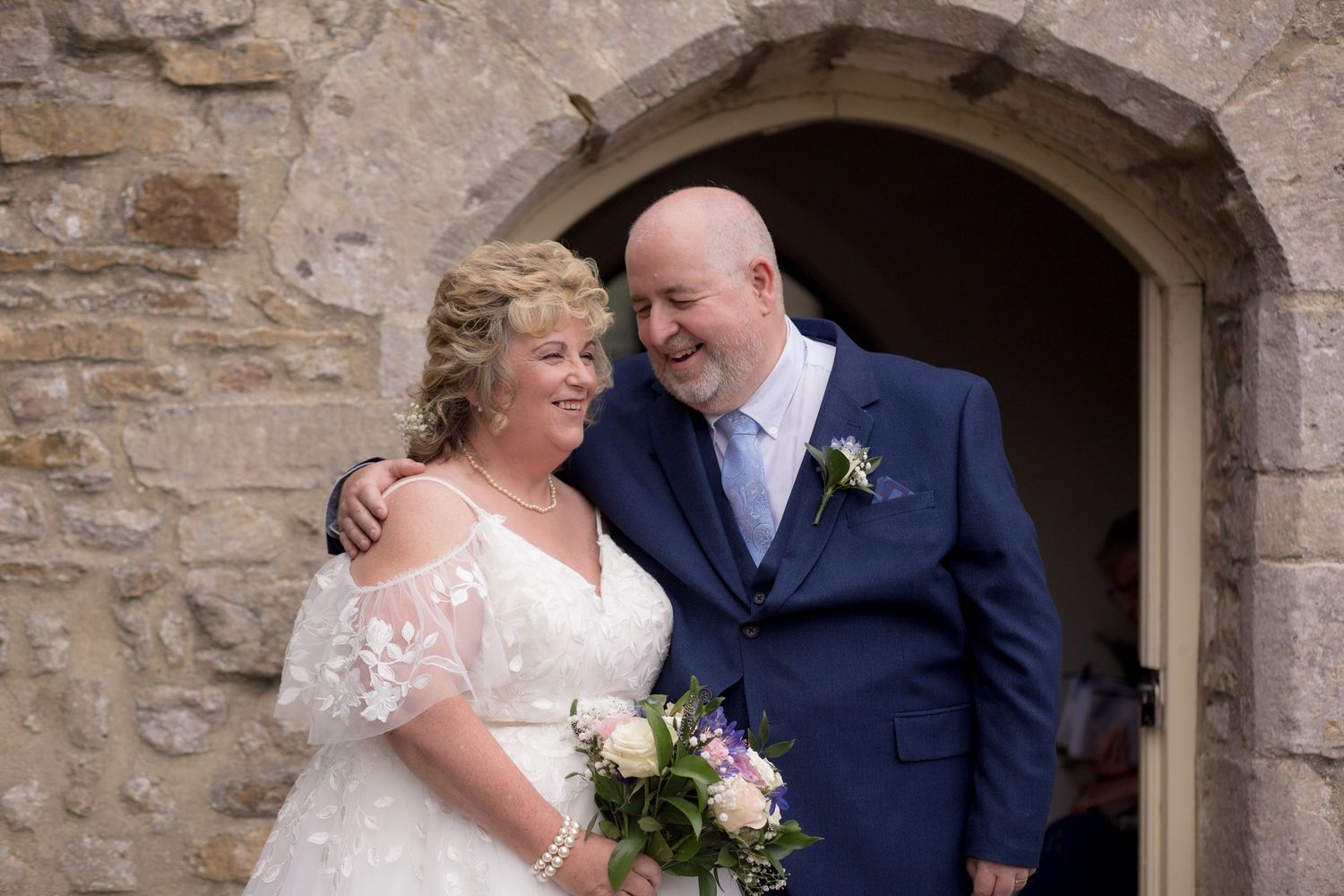 Bride and Groom have a small laugh together outside of the church after their ceremony