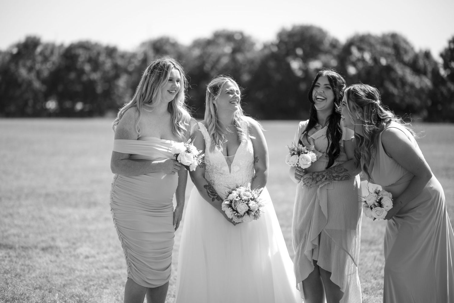 Bride and her three bridesmaids laughing together during group photos