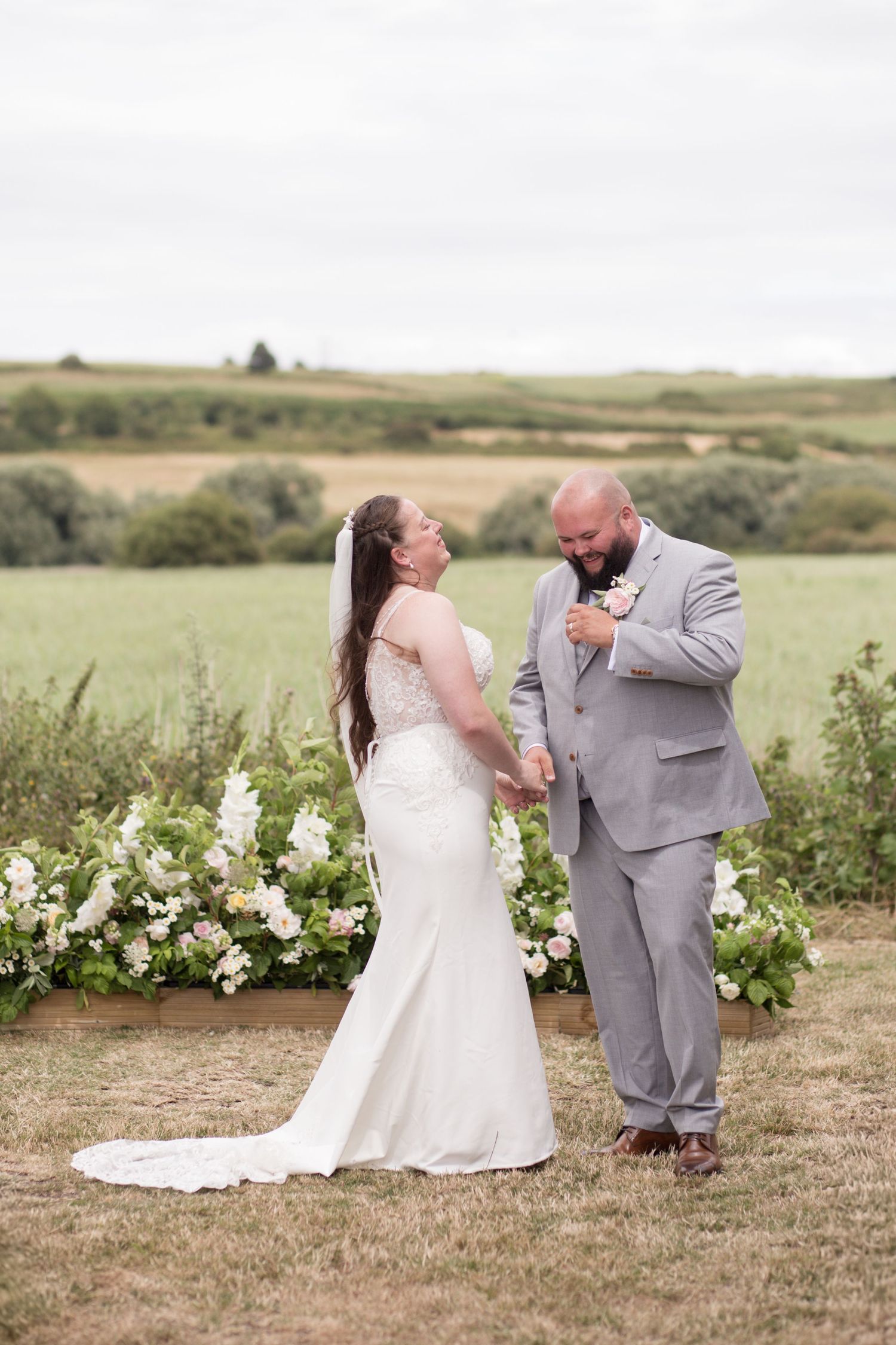 Bride and Groom laugh together for a moment during their outdoor ceremony in the fields of Weymouth Rugby Club