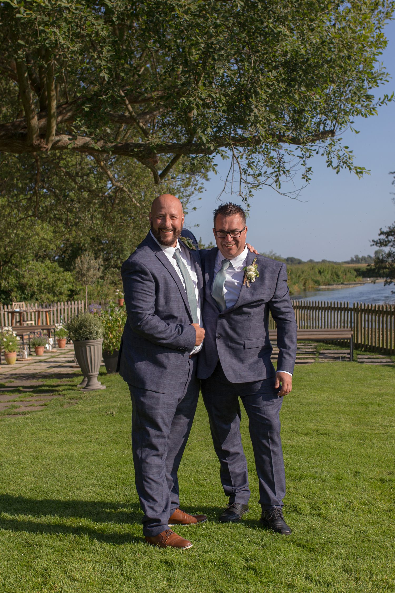Groom poses for a photo with his best man in the grounds of Sopley Mill