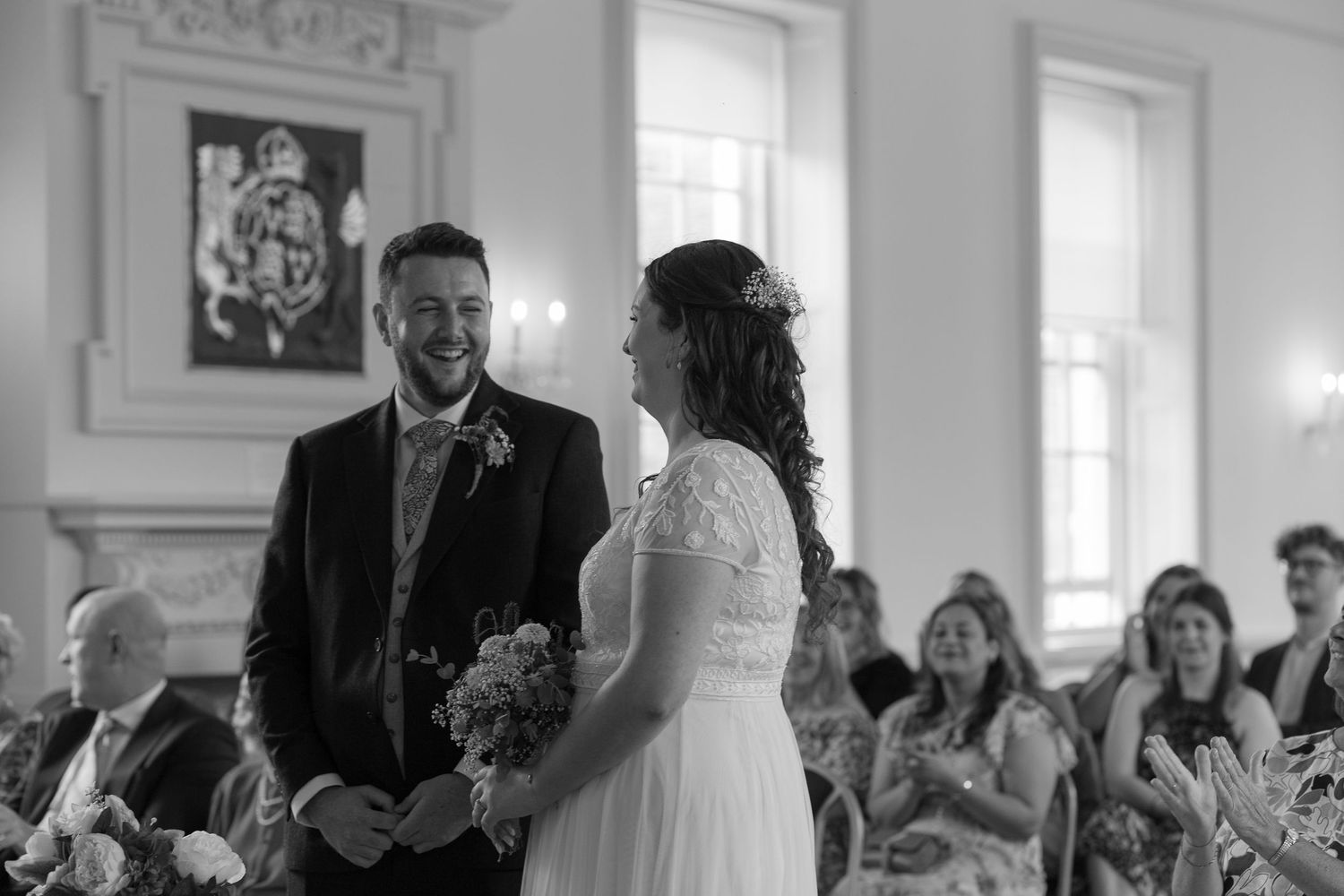 Bride and Groom laugh together in the middle of their wedding ceremony