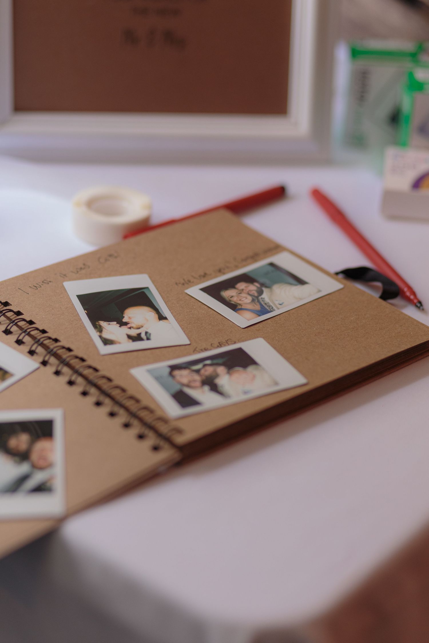 An open scrapbook page full of polaroids taken by wedding guests