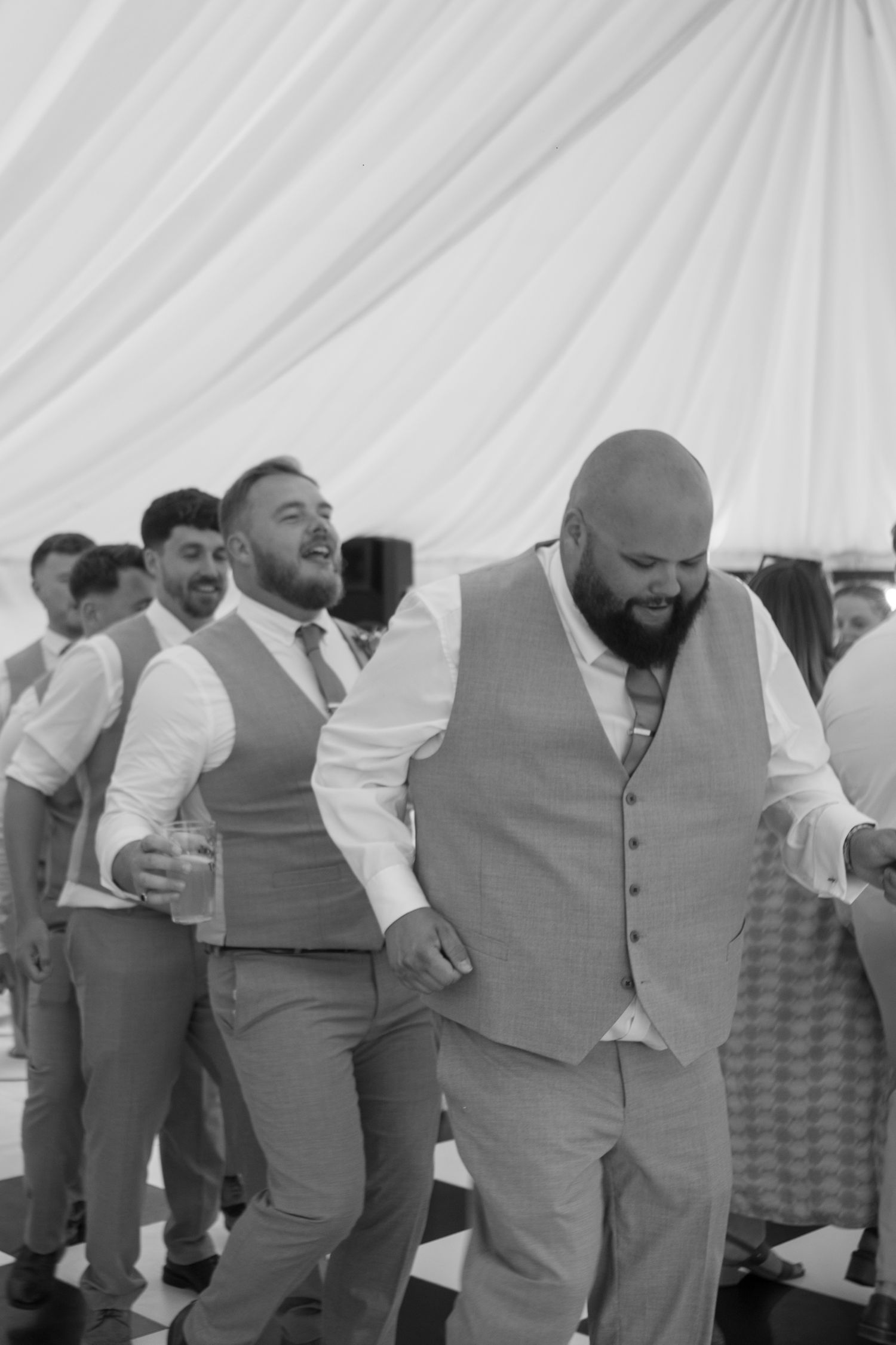 The groom and his groomsmen starting a dancing conga-esque line through the middle of the dancefloor.