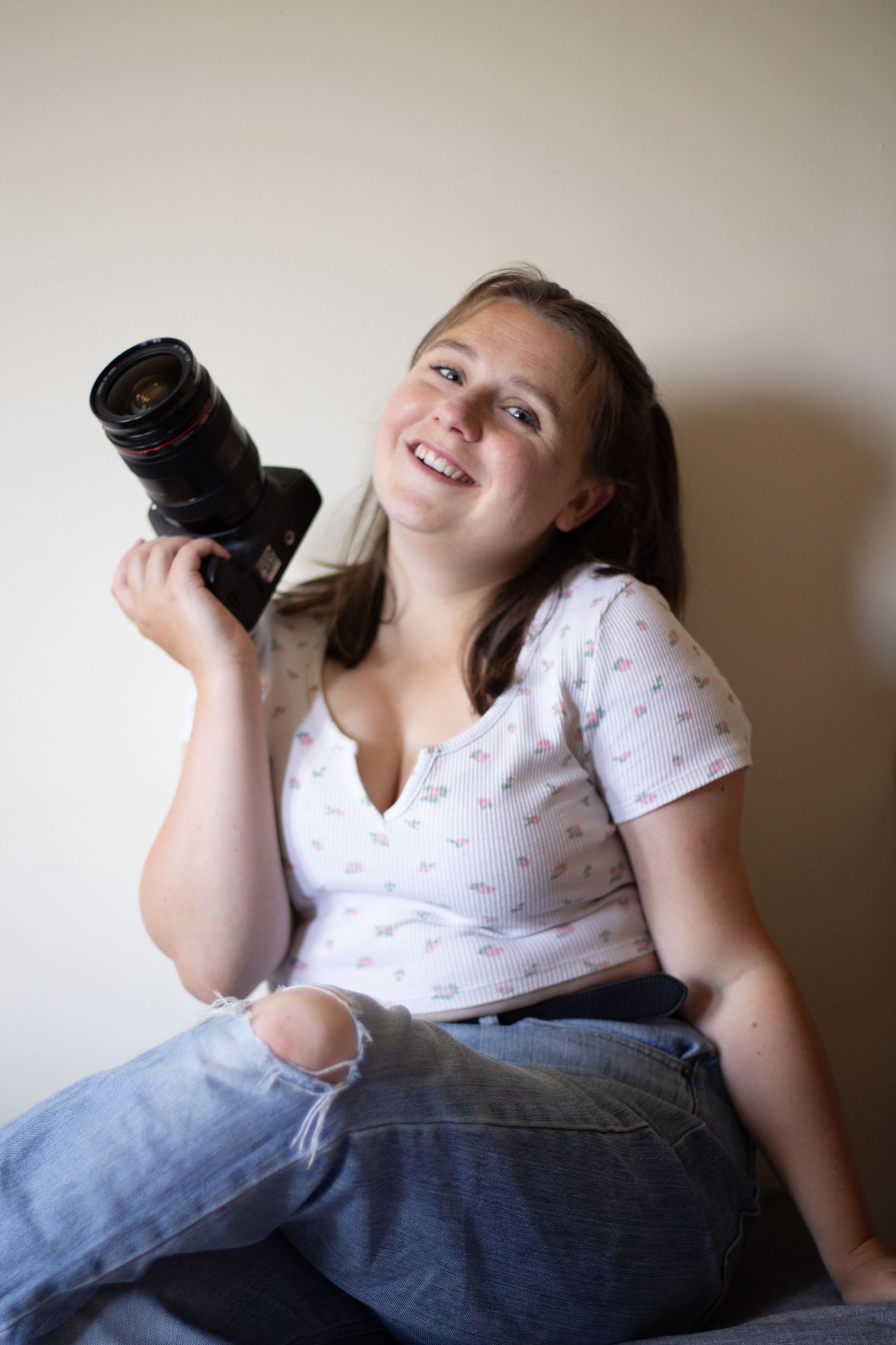 Rebecca Vallard Photography poses for a portrait holding her camera