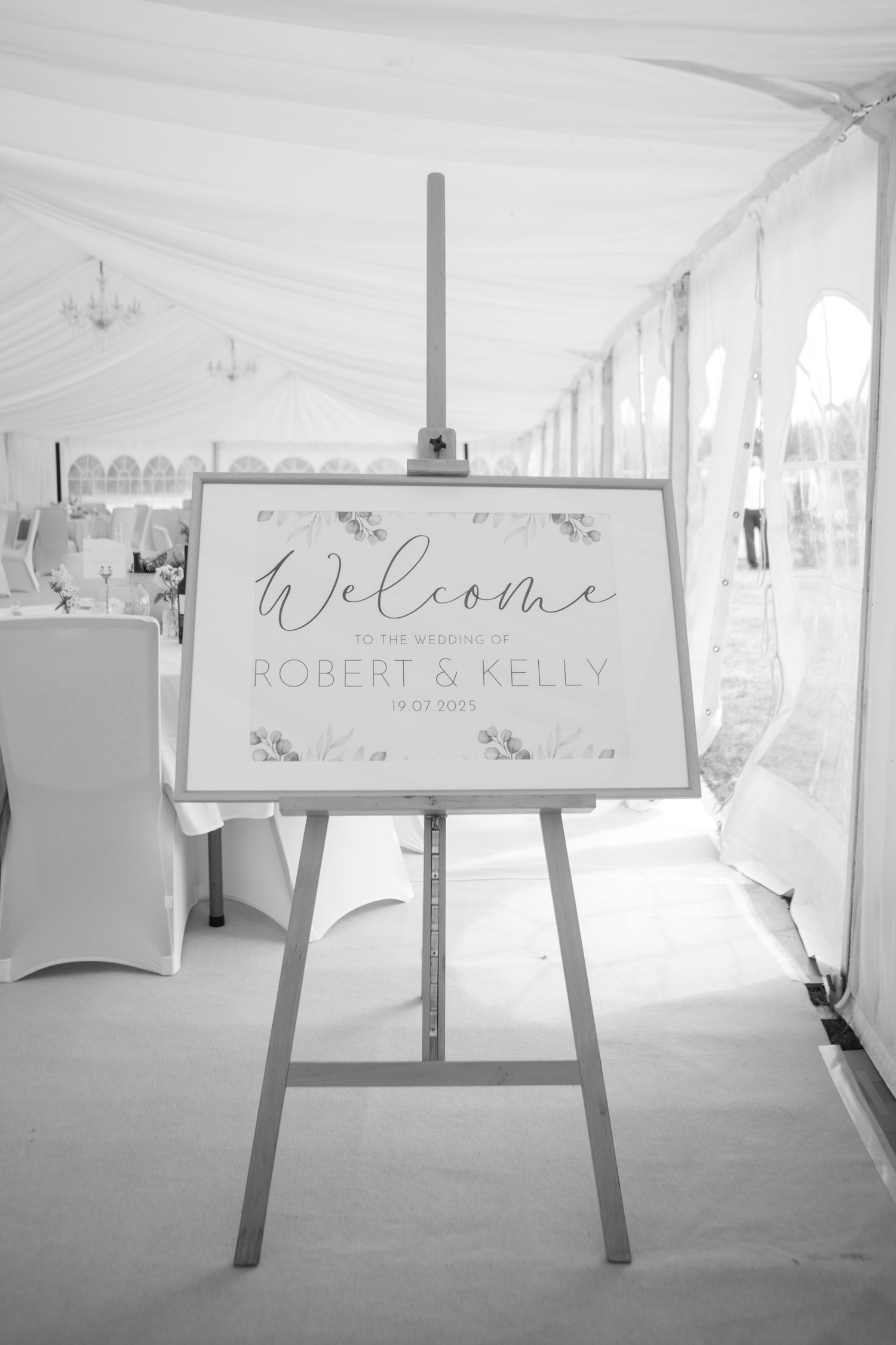 Black and white photo of a Wedding welcome sign placed on an easel