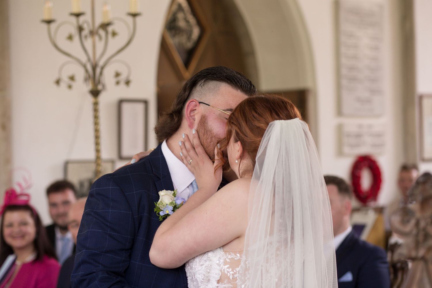 Bride and Groom share their first kiss in the middle of their church wedding