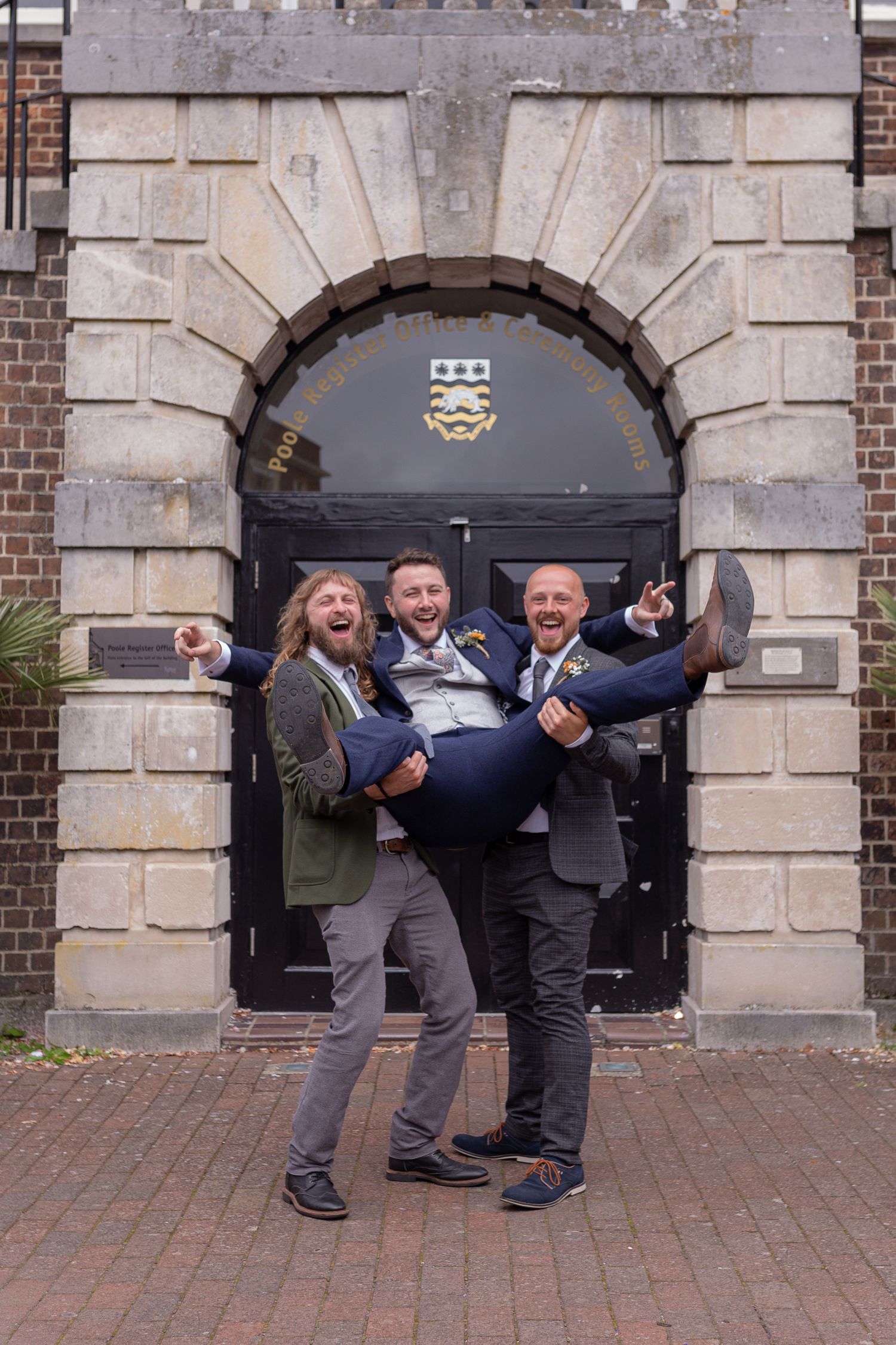 Groom gets lifted into the air by his two best men