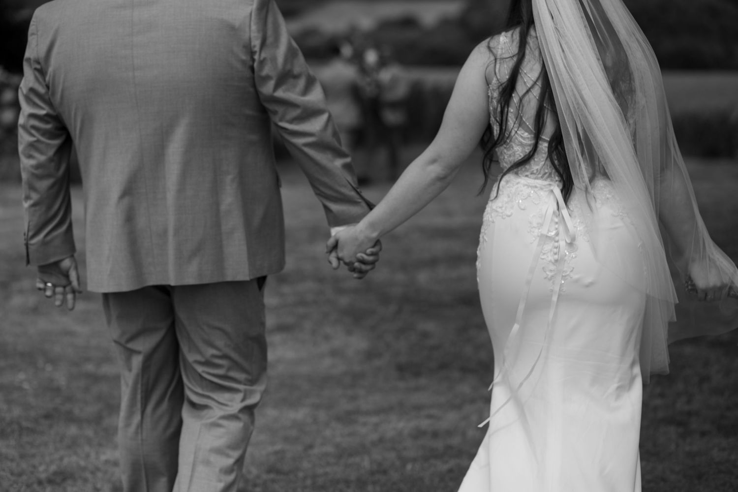 Bride and Groom hold hands and walk away from the camera