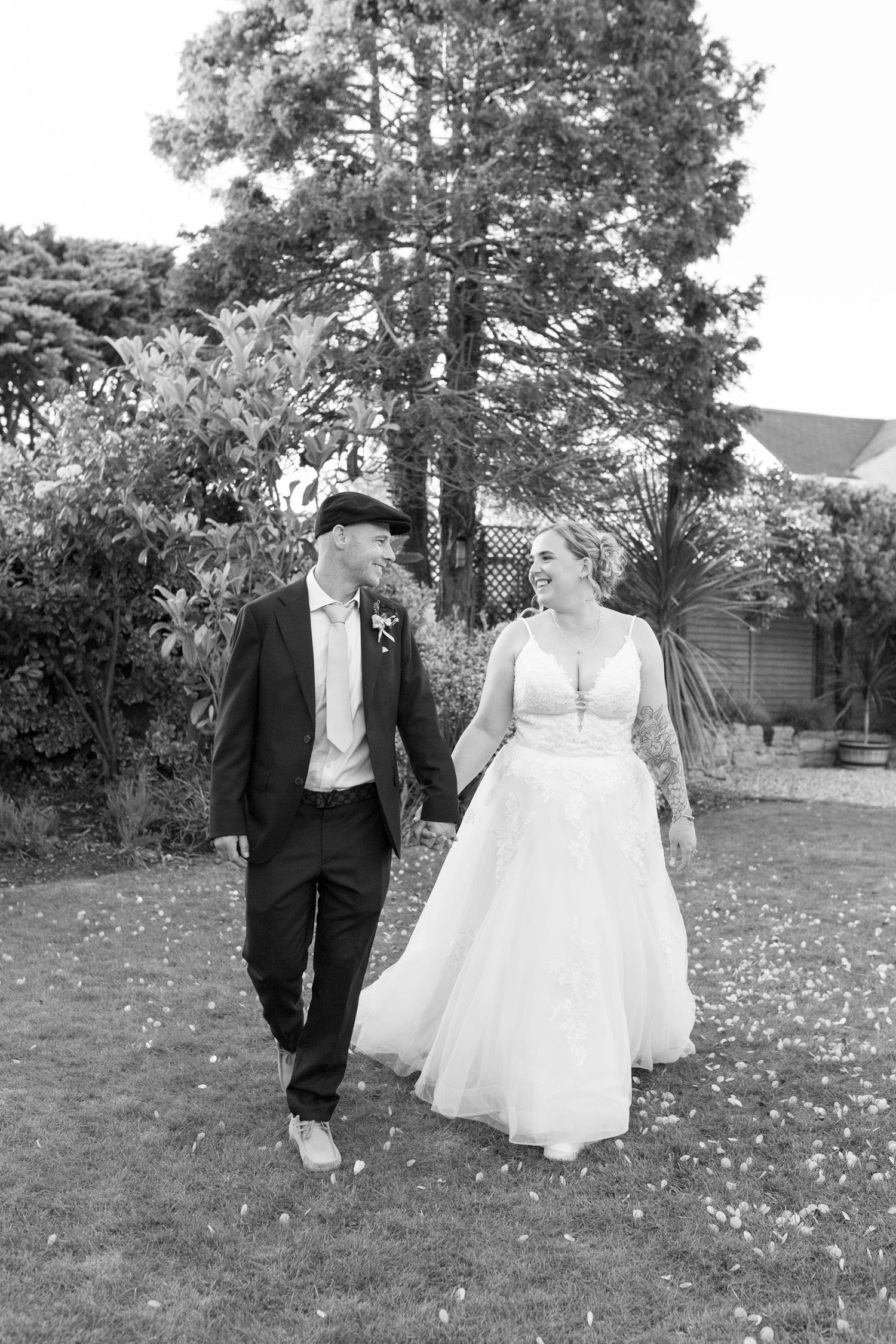 Black and White photo of a bride and groom walking together looking into each others eyes.