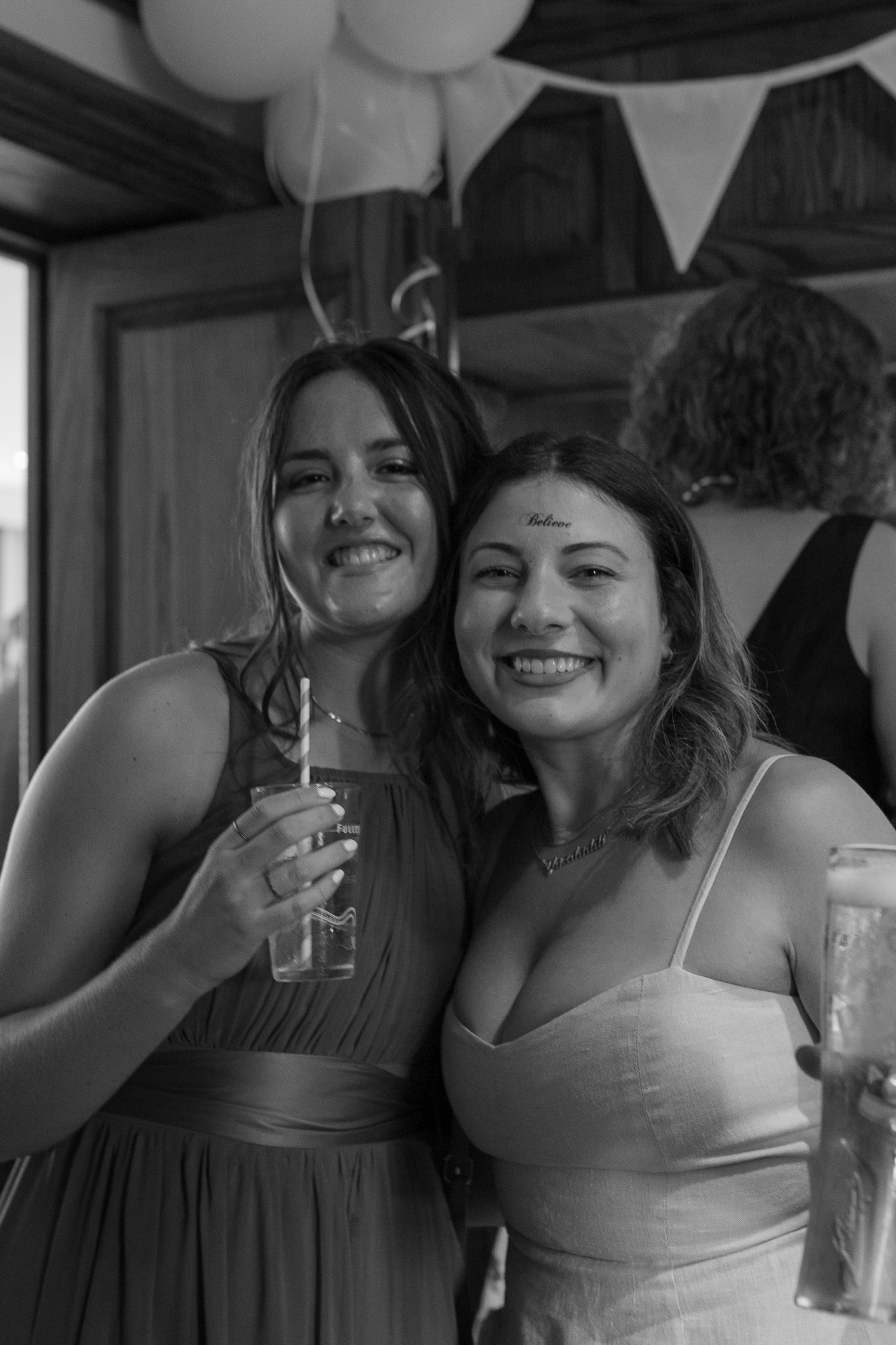 Two women, arms wrapped round each other, smile for a photo