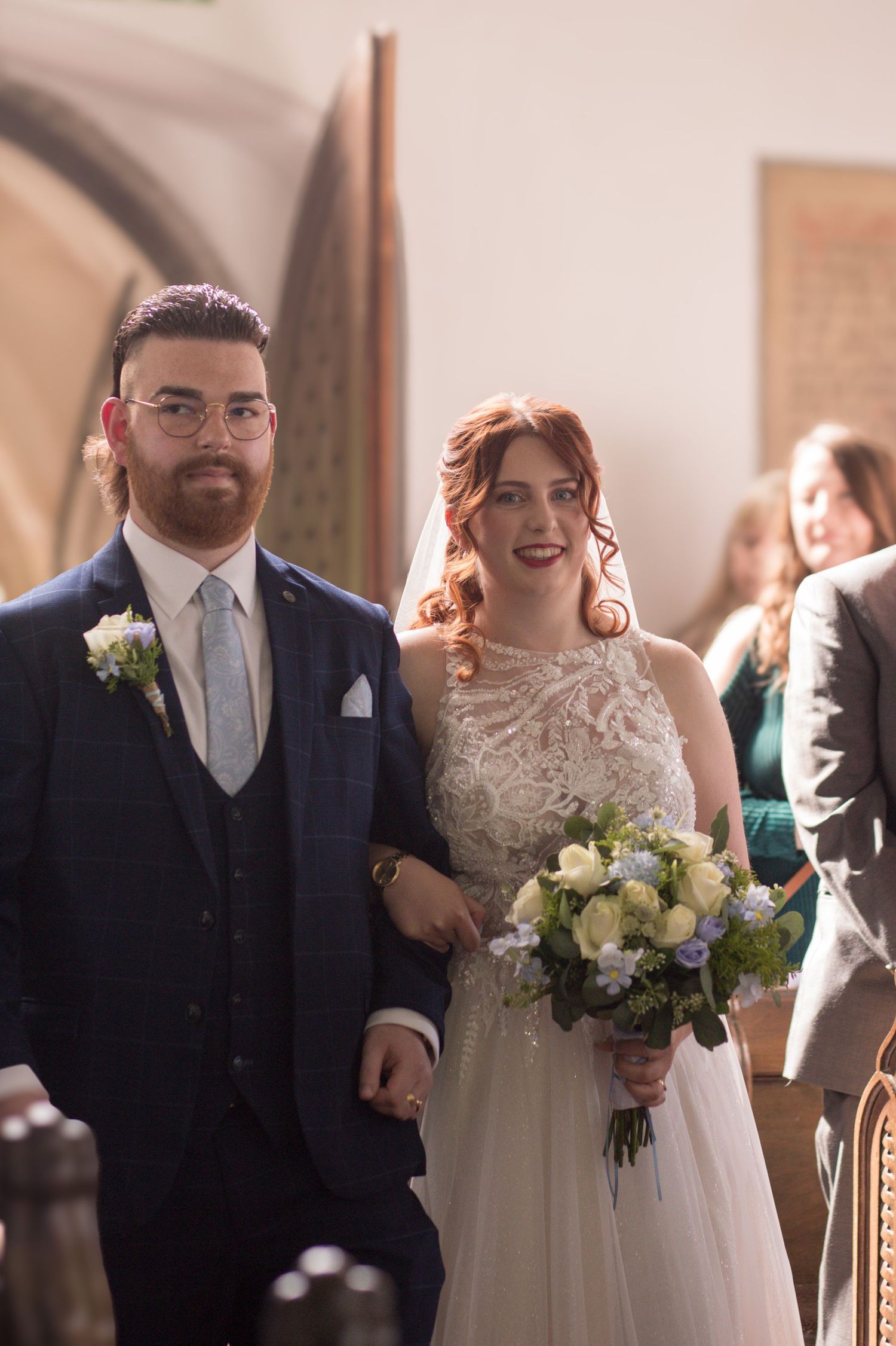 Bride and Groom walk down the aisle together on the way into their church blessing