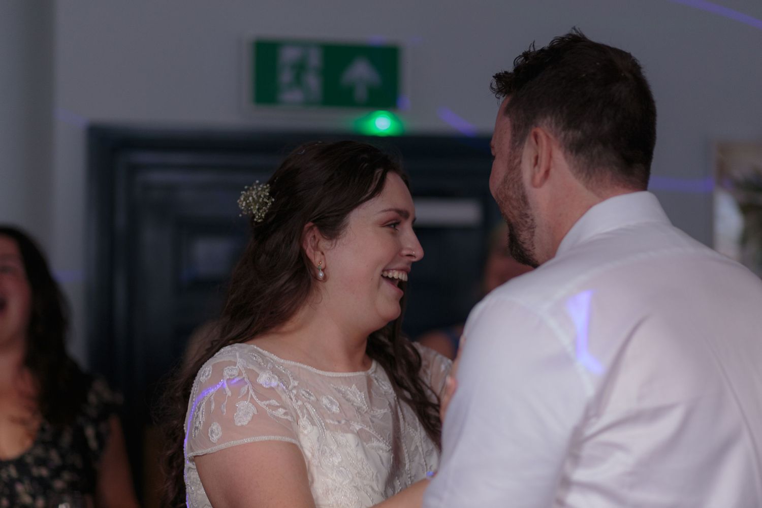 Bride and groom laugh to each other in the middle of their first dance.