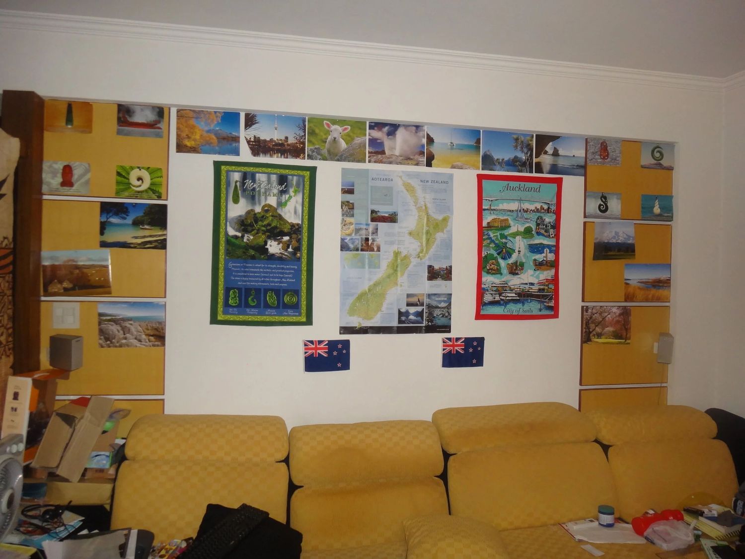 Yellow wall decorated with photos and artwork in a room with couches.