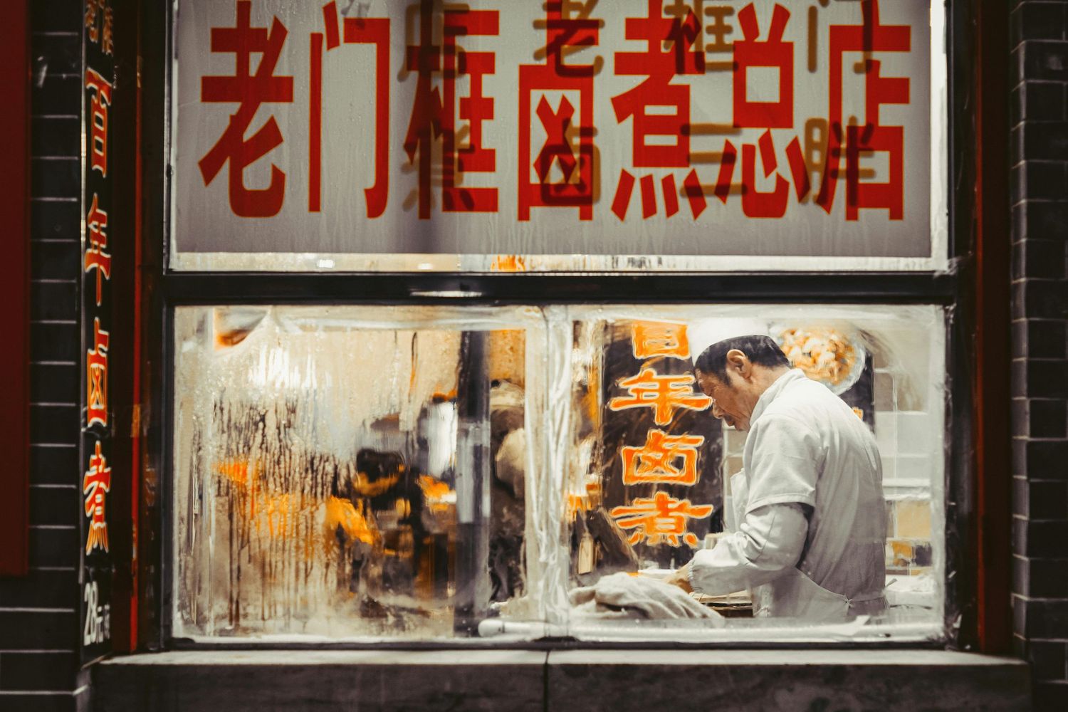 Traditional Chinese storefront with red characters and signage displayed in the windows.