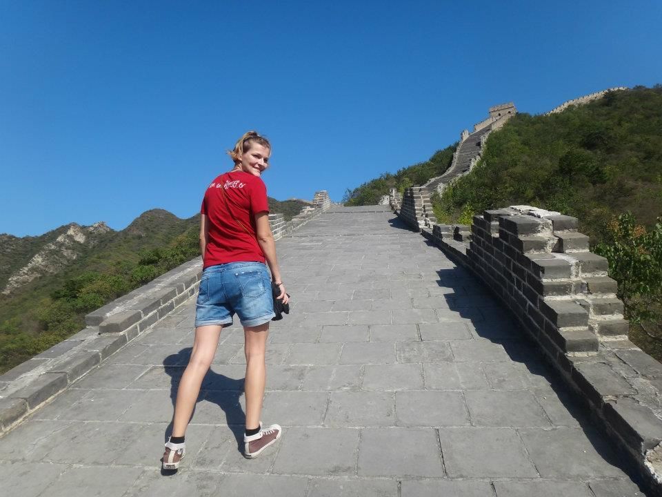 Steep stone steps leading up the Great Wall of China with mountains visible in the distance.