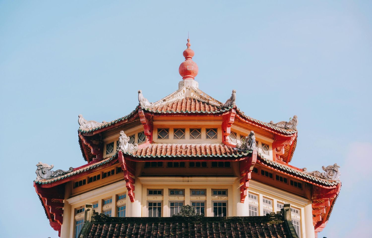Traditional Chinese temple rooflines with ornate details against clear blue sky.